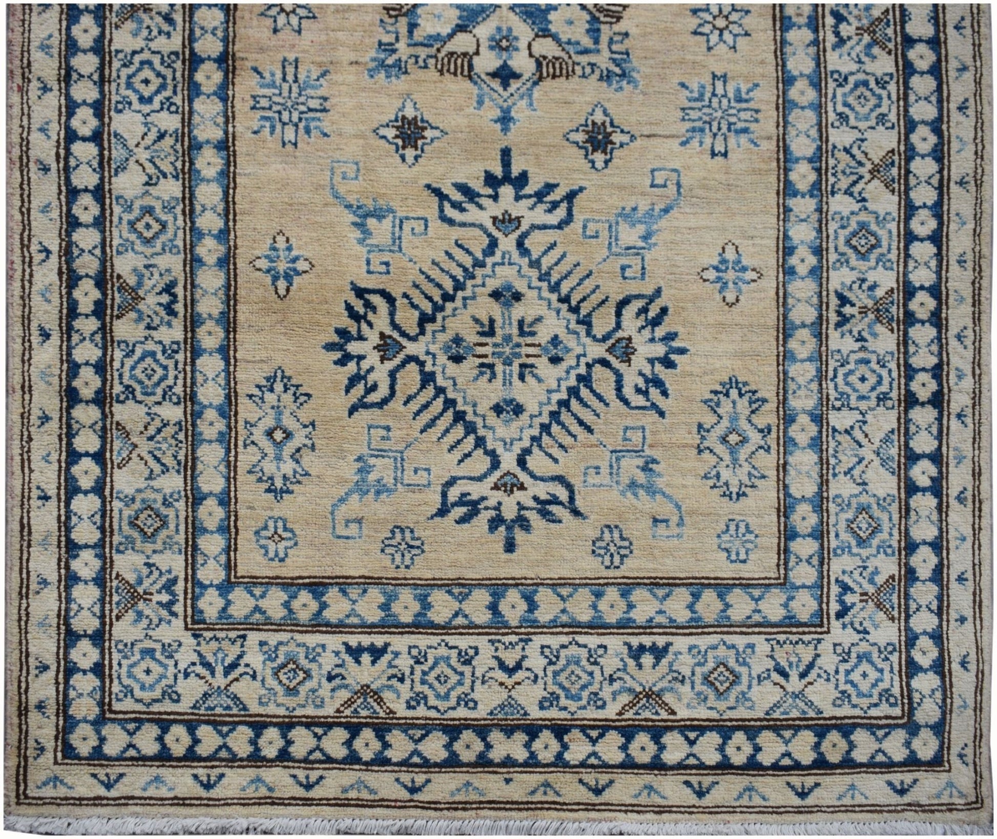 Handmade Afghan Super Kazakh runner rug featuring a blue geometric medallion on a beige field.