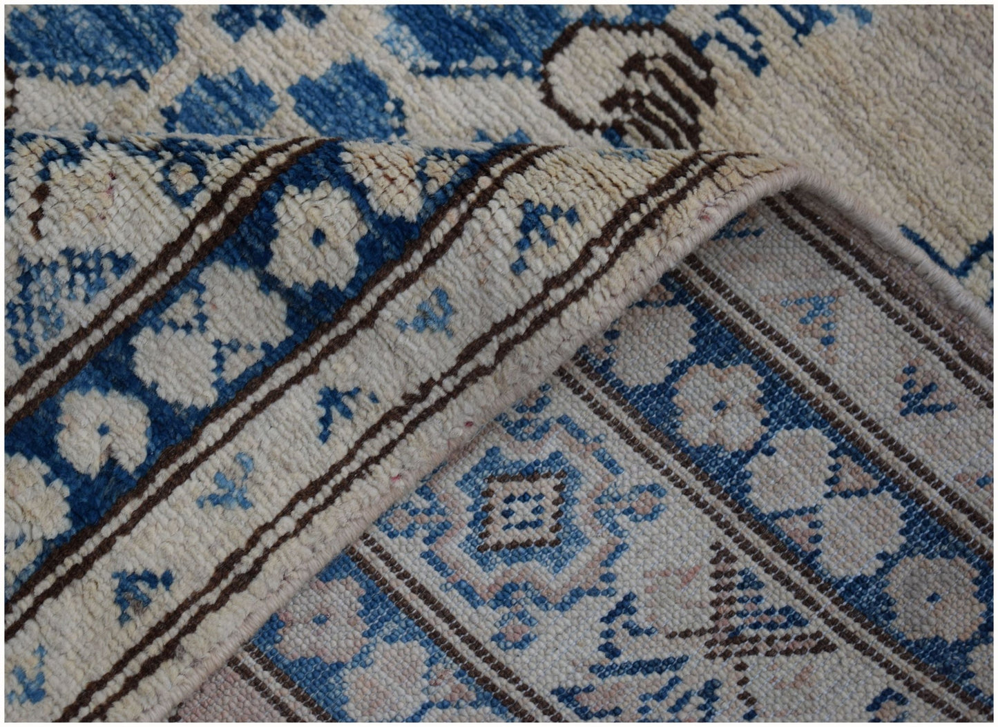 A handmade Afghan Super Kazakh runner featuring traditional blue and cream geometric patterns.