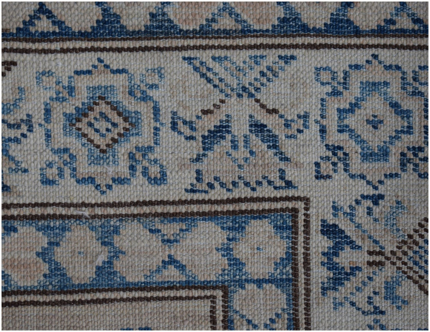 A close-up of an Afghan Super Kazakh runner featuring traditional blue and beige geometric motifs.