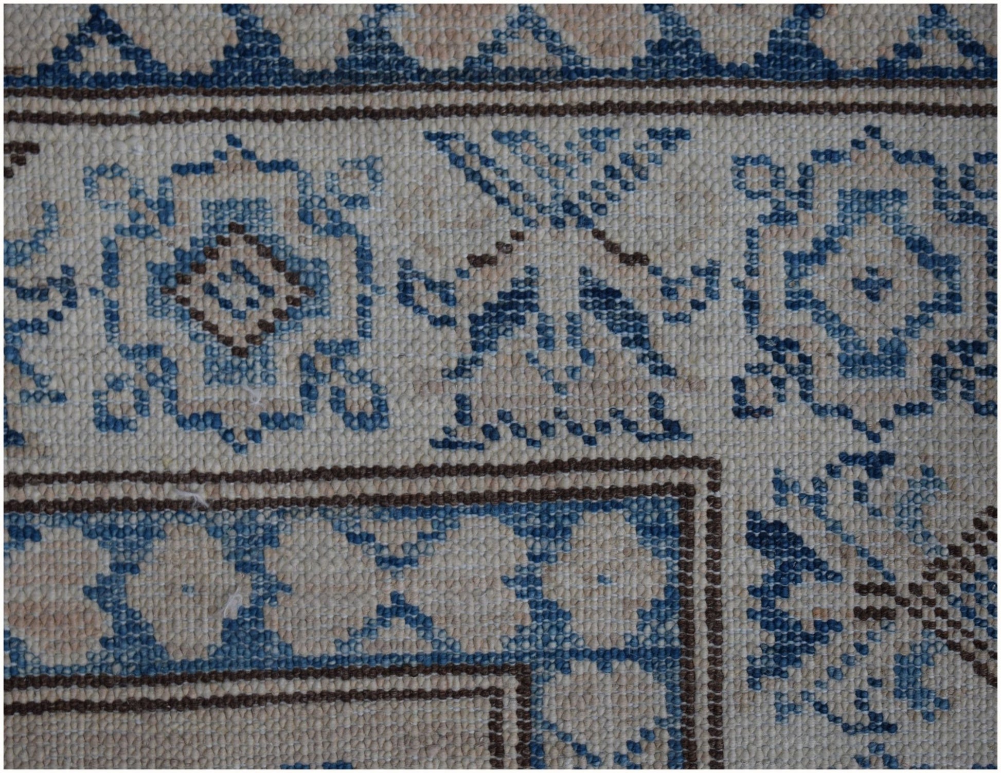 A close-up of an Afghan Super Kazakh runner featuring traditional blue and beige geometric motifs.