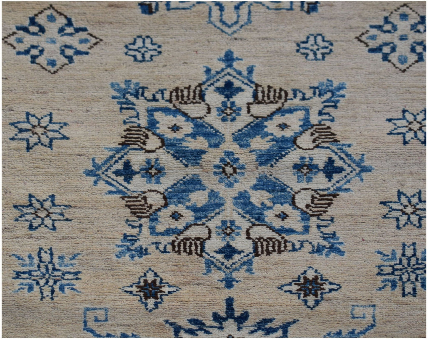 An Afghan Super Kazakh runner rug featuring a central blue and brown geometric floral medallion.