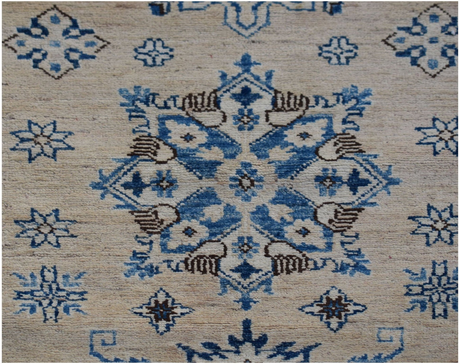 An Afghan Super Kazakh runner rug featuring a central blue and brown geometric floral medallion.