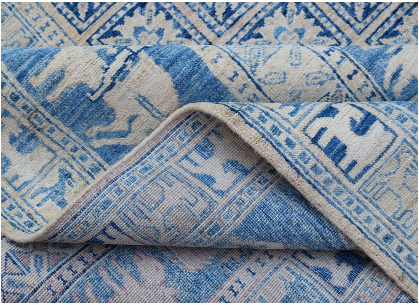 A blue and cream Afghan Chobi rug with traditional Pazyryk geometric patterns.