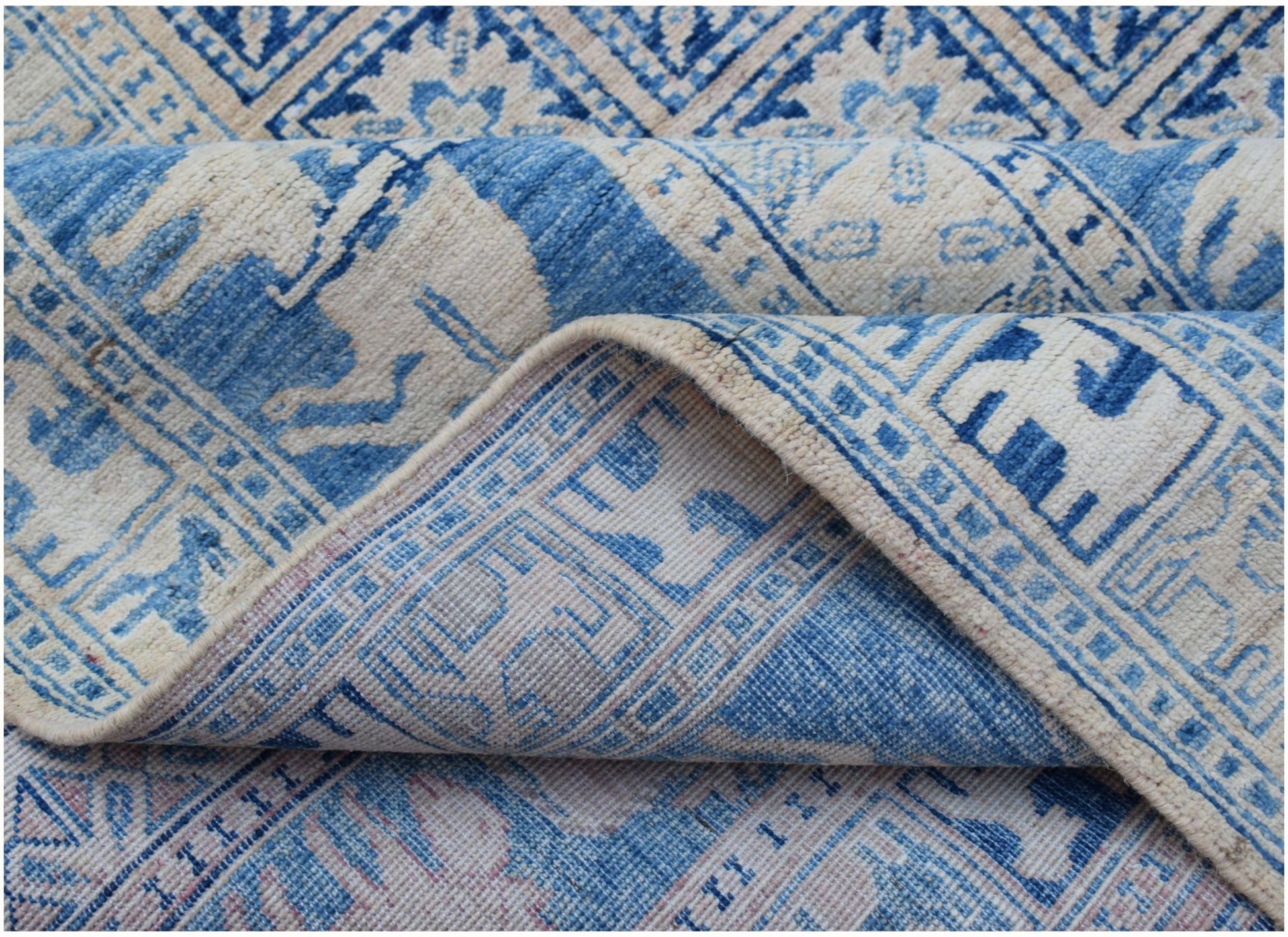 A blue and cream Afghan Chobi rug with traditional Pazyryk geometric patterns.