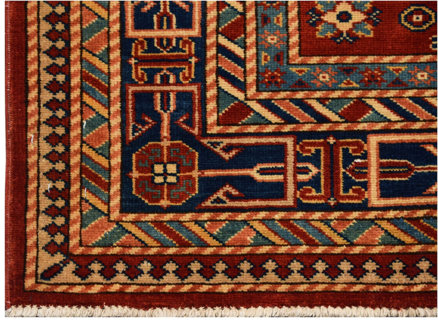 A handmade Afghan Super Kazakh rug featuring traditional geometric motifs in red and blue.