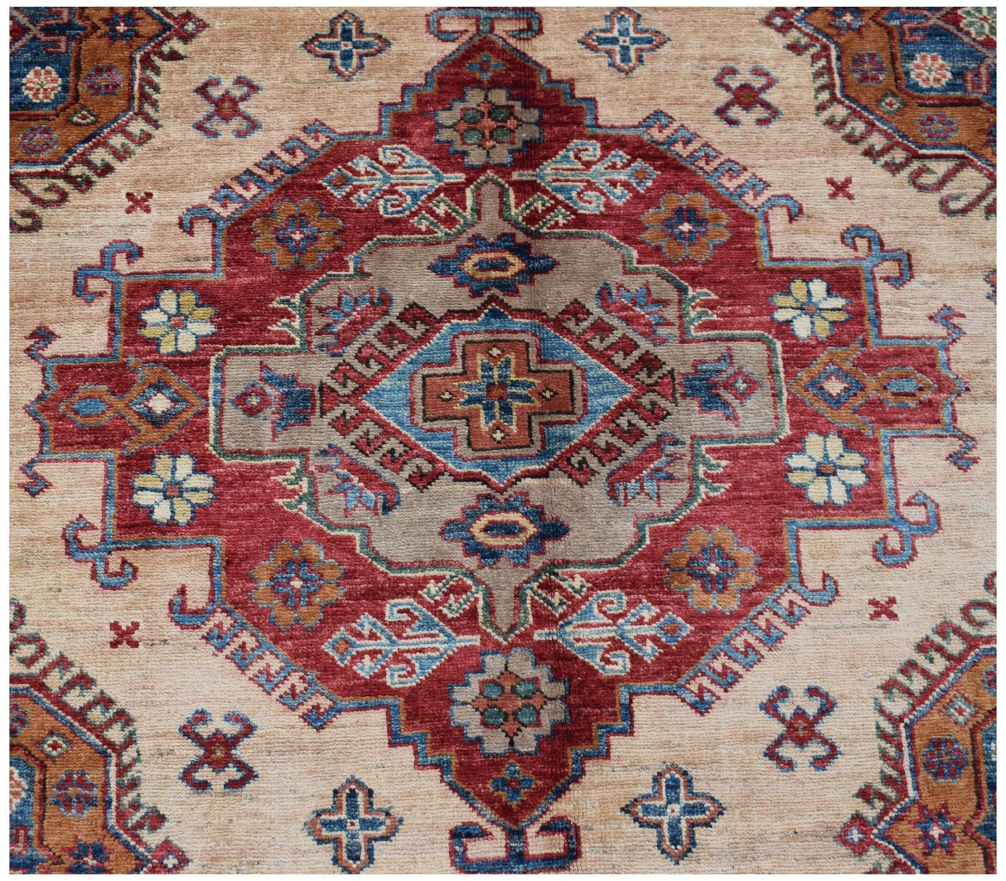 Handmade Afghan Super Kazakh rug featuring a traditional geometric medallion in red and blue.