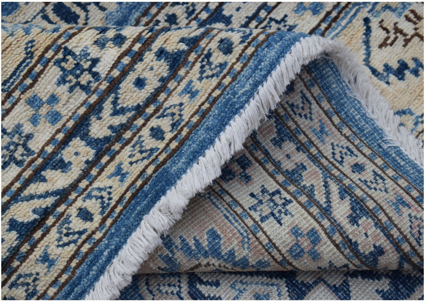 A handmade Afghan Super Kazakh rug featuring traditional blue and cream geometric patterns.