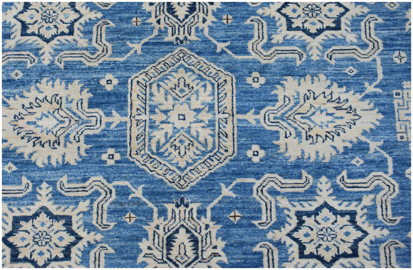 Handmade Afghan Super Kazakh rug featuring traditional geometric motifs in blue and cream wool.