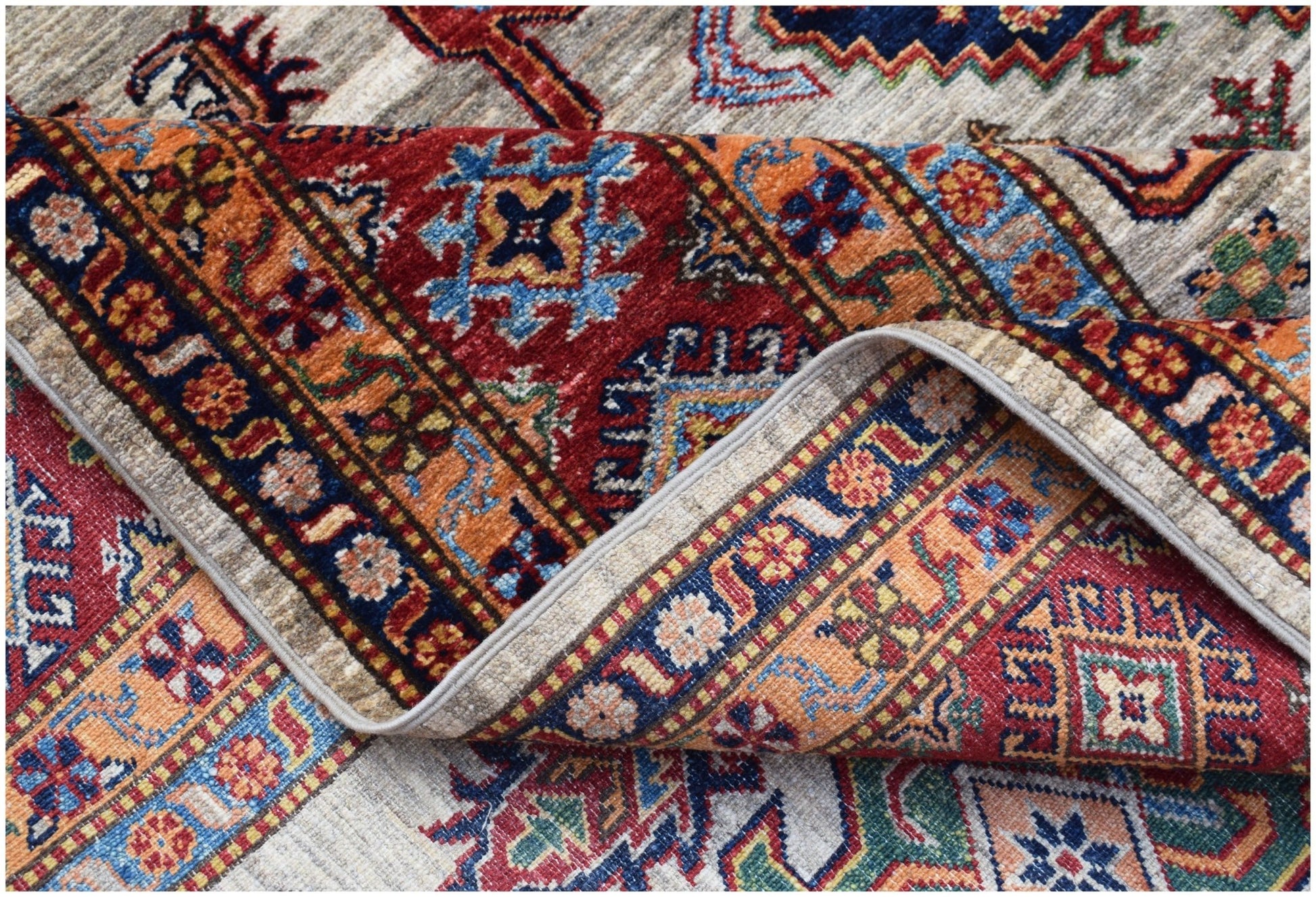 A hand-knotted Afghan Super Kazakh rug featuring traditional geometric motifs in vibrant colors.