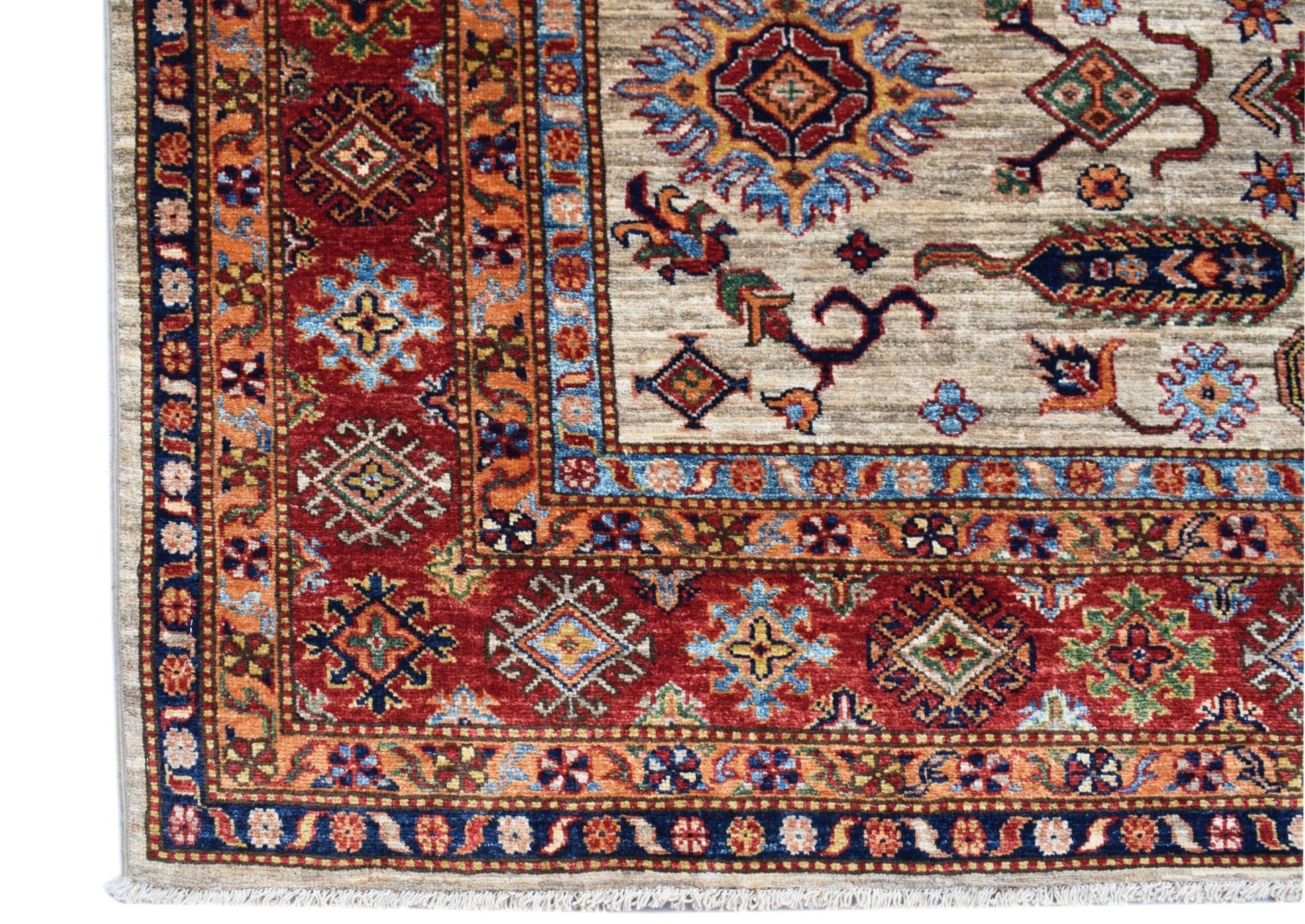 A handmade Afghan Super Kazakh rug featuring traditional geometric motifs in red, blue, and beige.