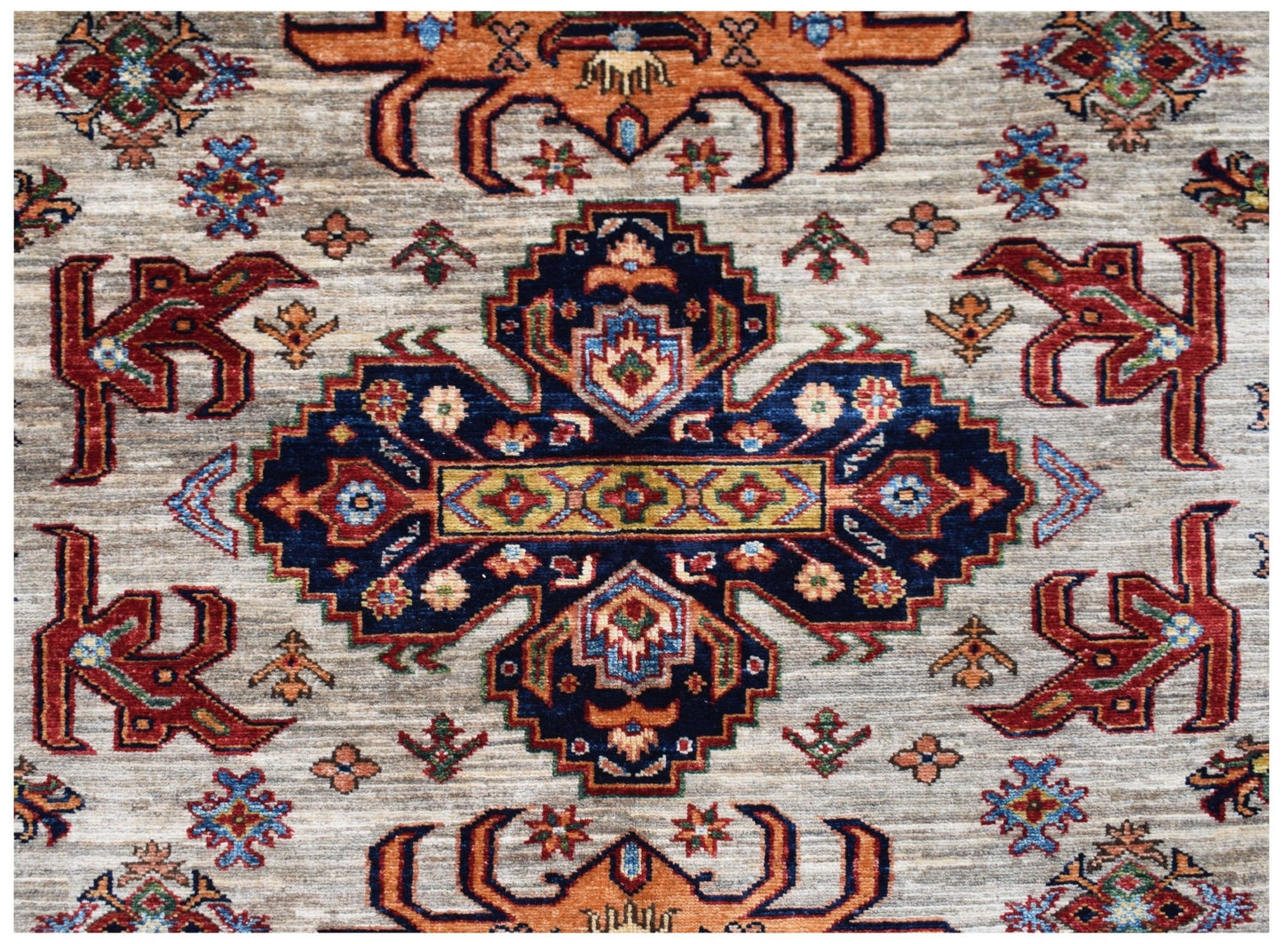 Handmade Afghan Super Kazakh rug featuring a central blue medallion with traditional geometric motifs.