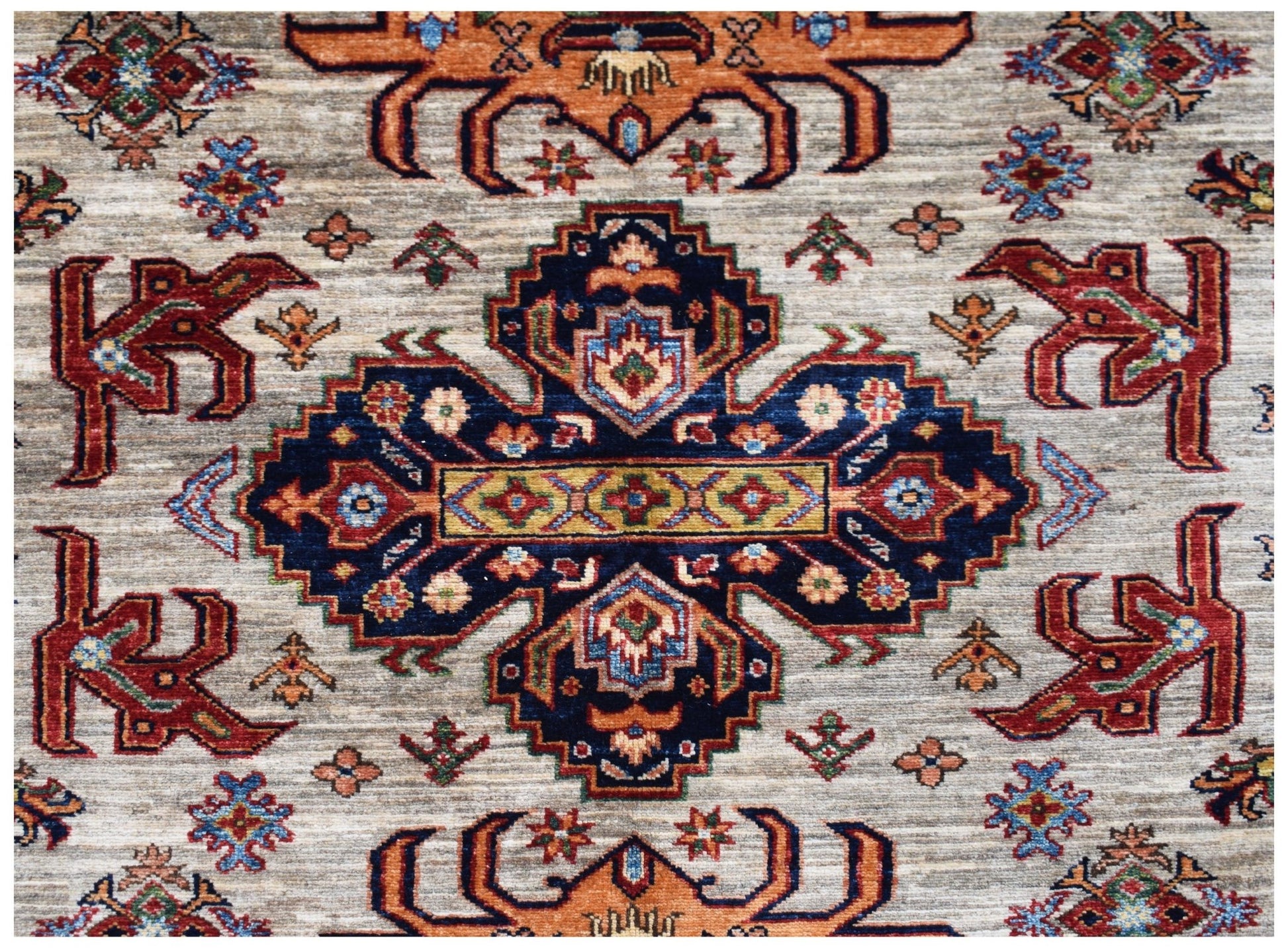 Handmade Afghan Super Kazakh rug featuring a central blue medallion with traditional geometric motifs.