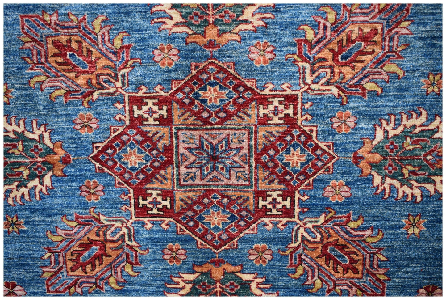 Handmade Afghan Super Kazakh rug featuring a central geometric medallion on a blue field.