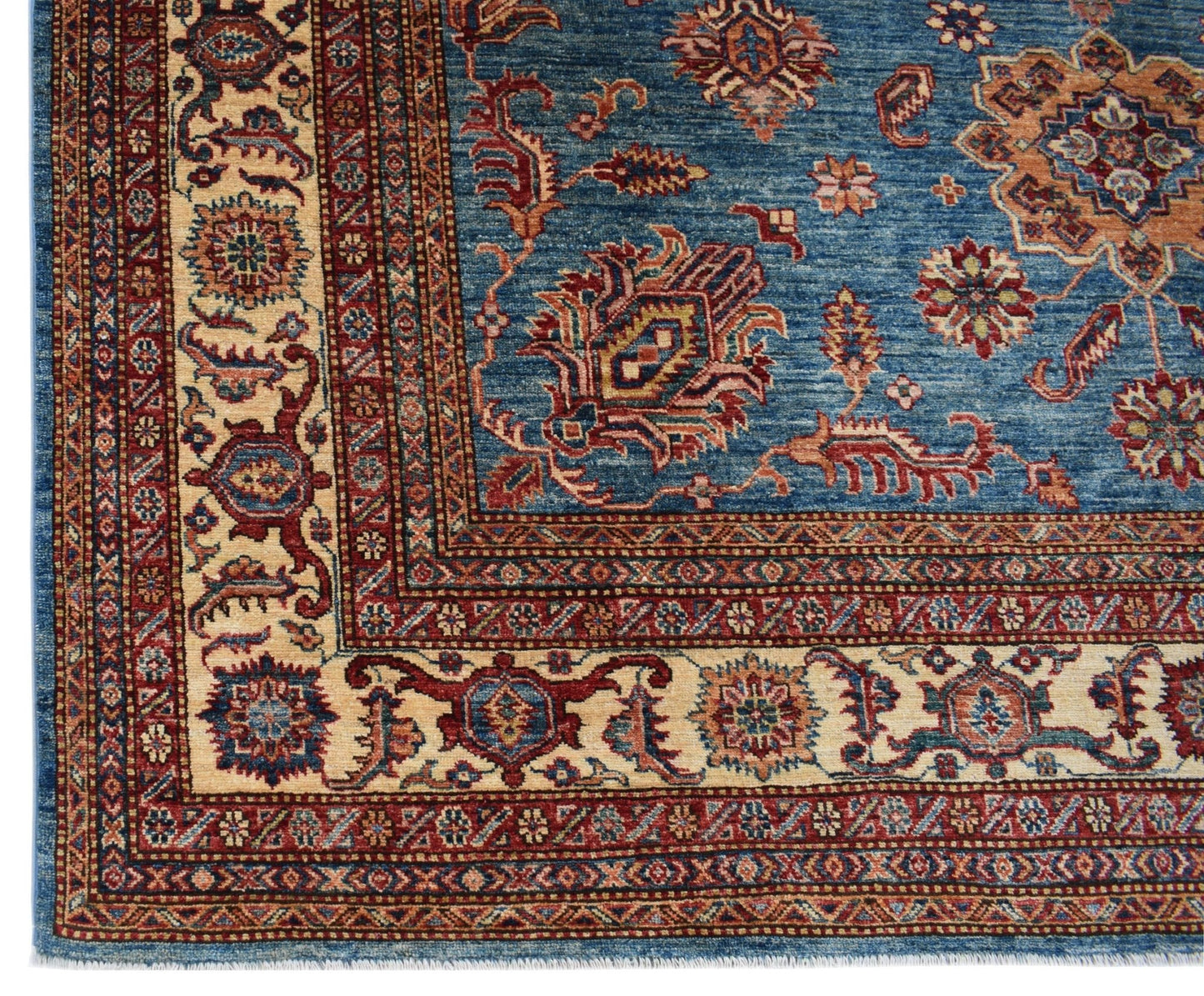 A handmade Afghan Super Kazakh rug featuring traditional geometric motifs in blue, red, and cream.