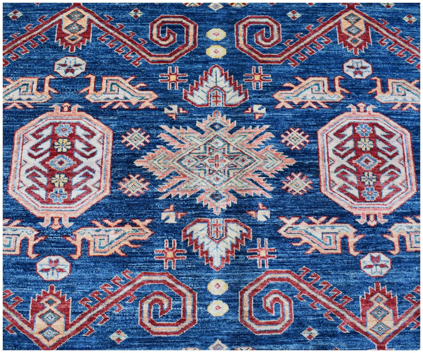 An Afghan Super Kazakh rug featuring traditional geometric motifs in red, blue, and cream tones.
