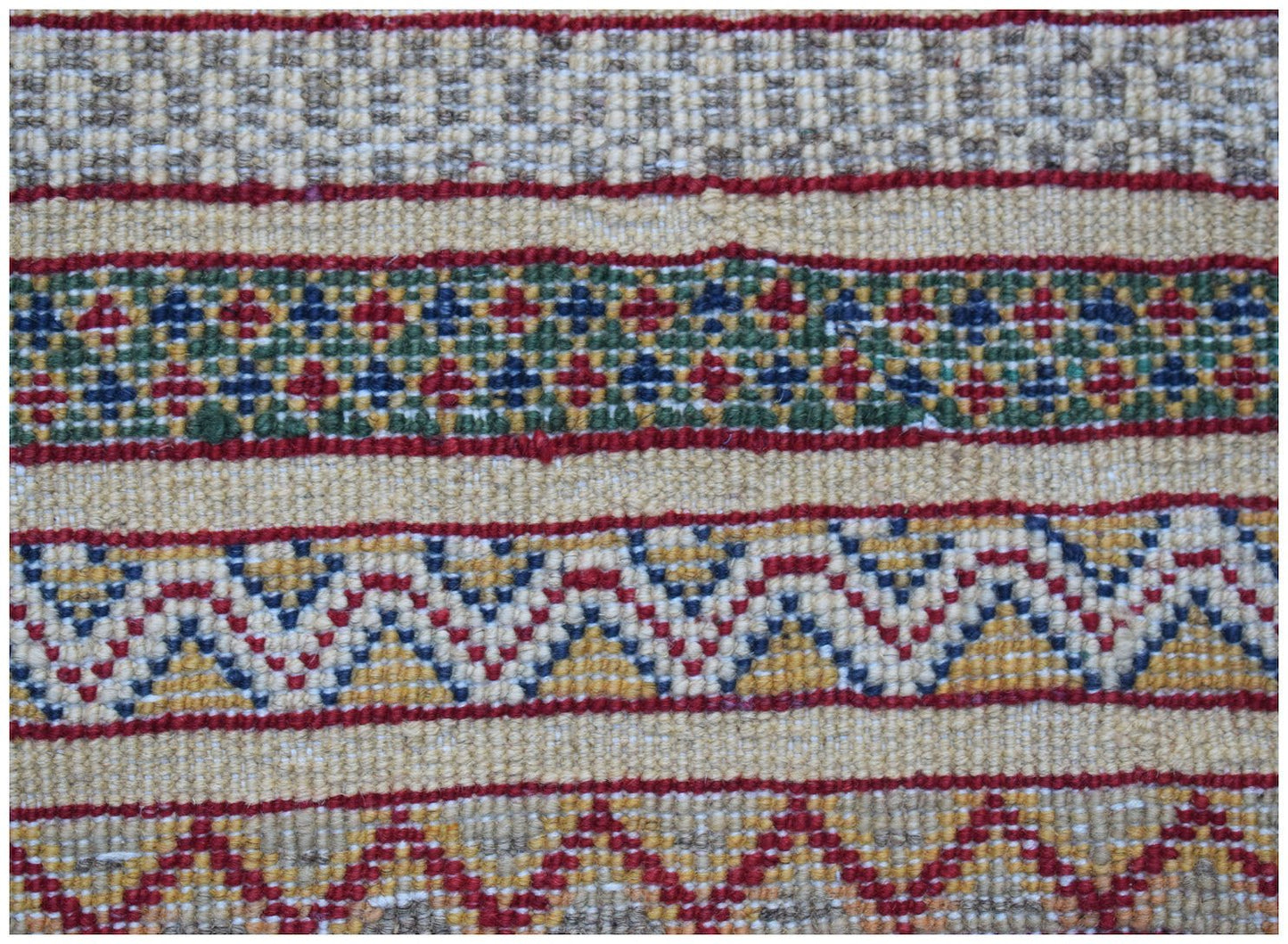 A close-up of an Afghan Yekta runner featuring horizontal bands of geometric and zigzag patterns.
