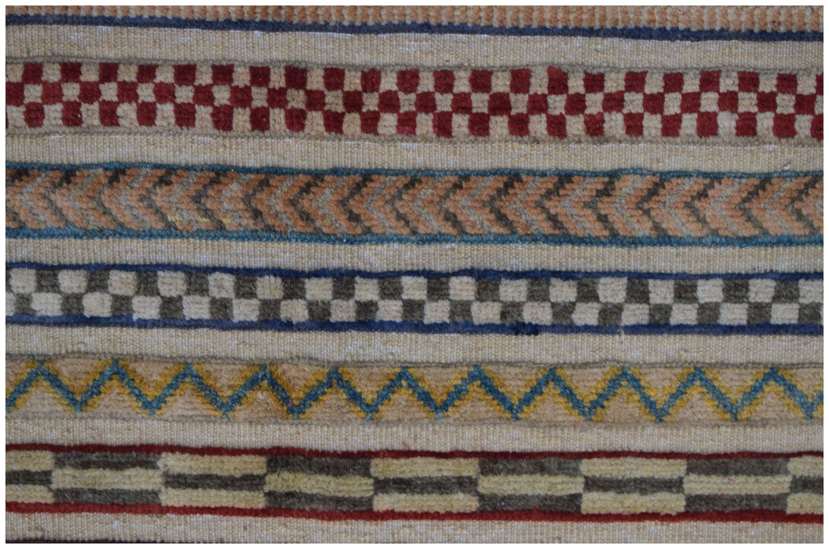 An Afghan Yekta runner featuring horizontal bands of geometric patterns in wool on a cotton base.