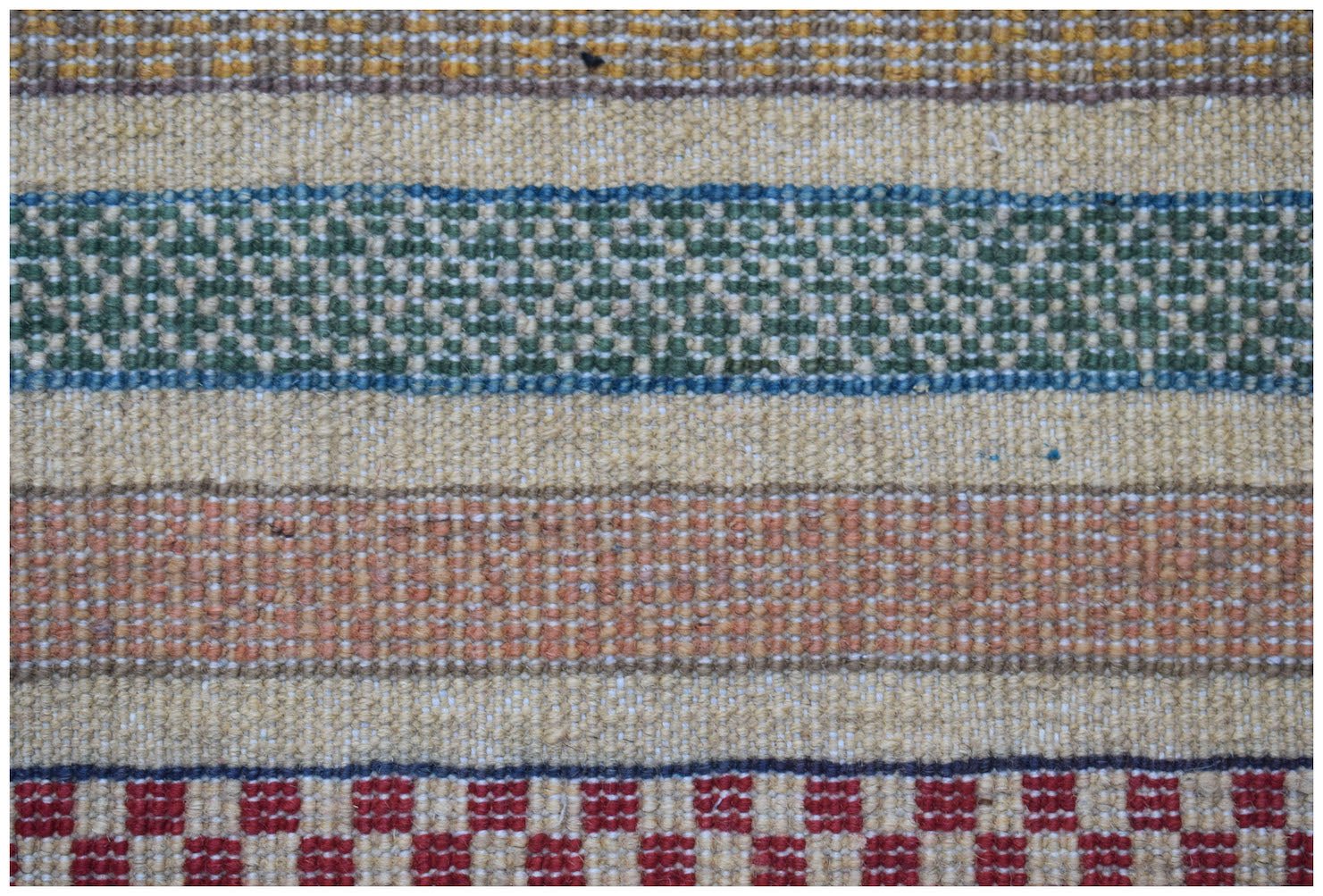A handmade Afghan runner featuring horizontal stripes of textured wool in green, orange, and red.