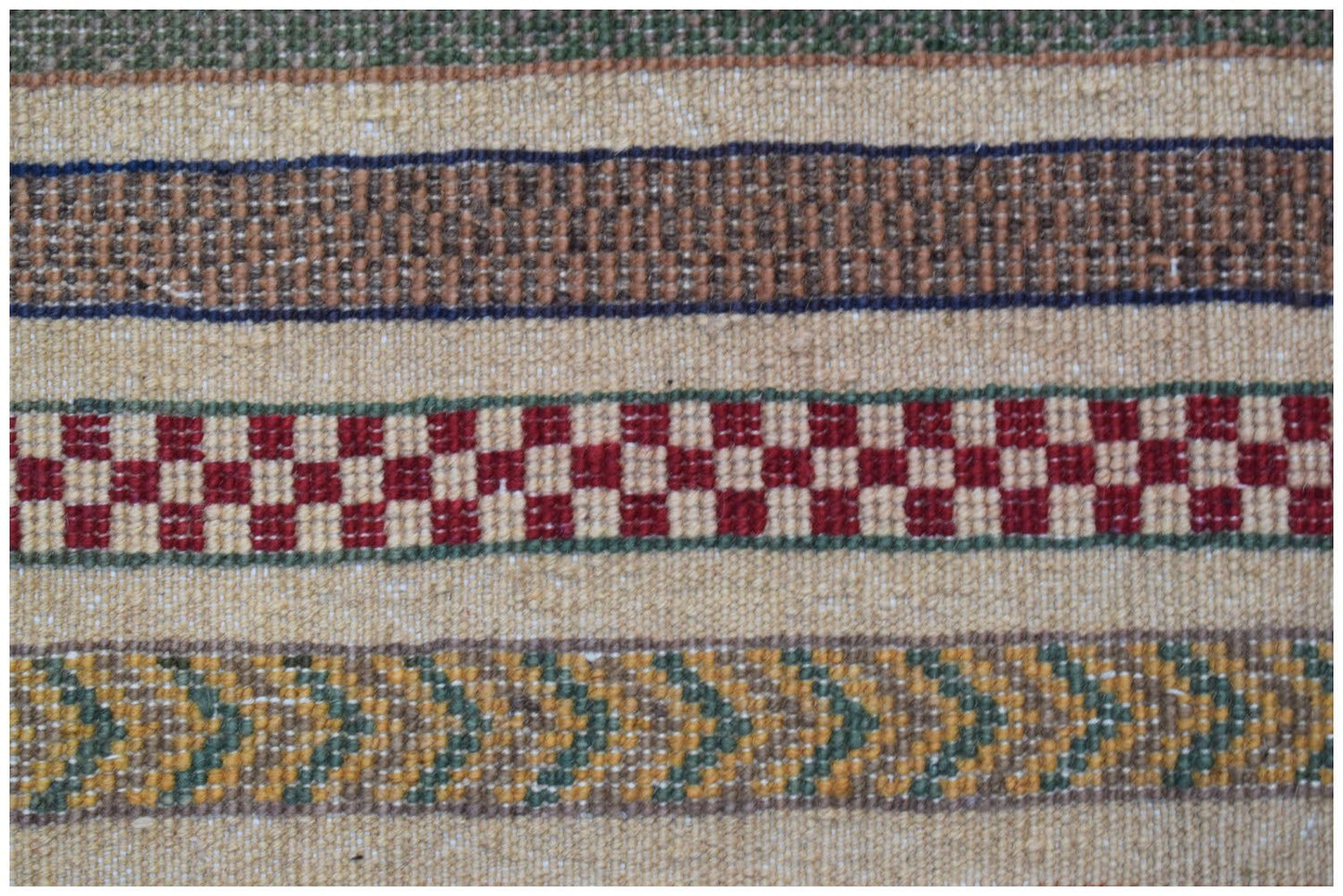 A handmade Afghan runner featuring horizontal bands of geometric patterns in red, green, and tan.