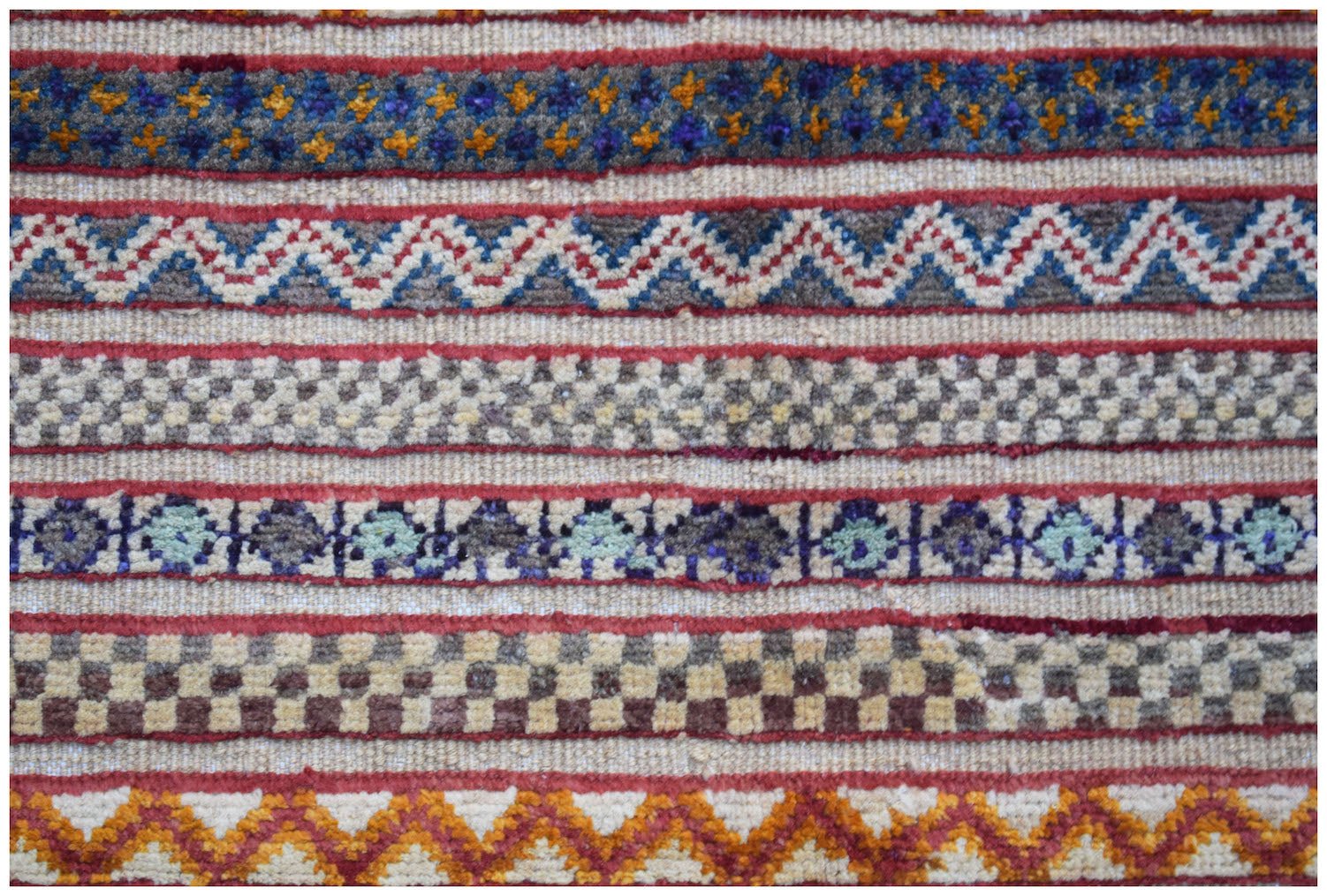 Handmade Afghan Yekta runner featuring horizontal bands of geometric patterns in wool.