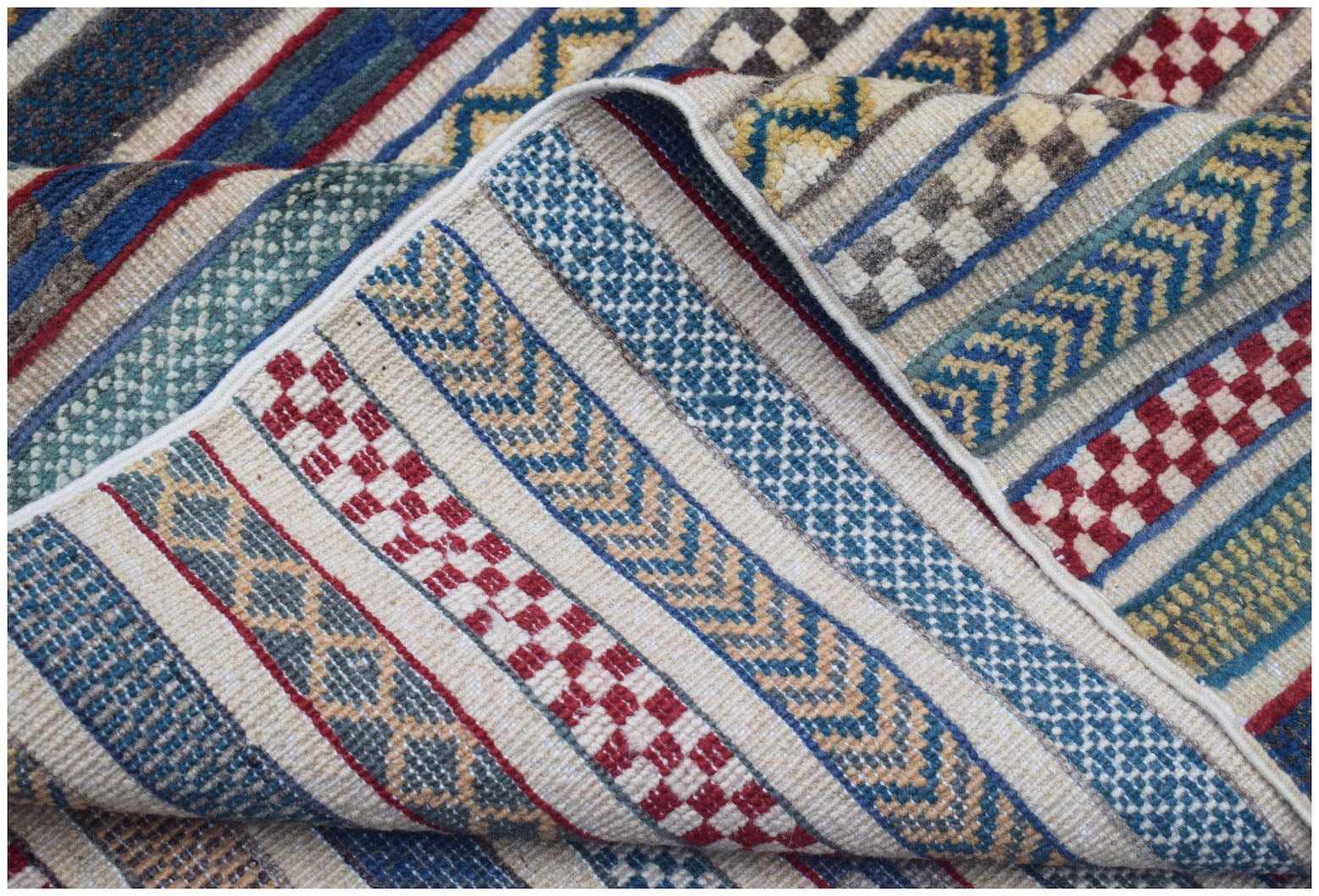A handmade Afghan Yekta rug featuring a textured, striped pattern of geometric and checkered motifs.