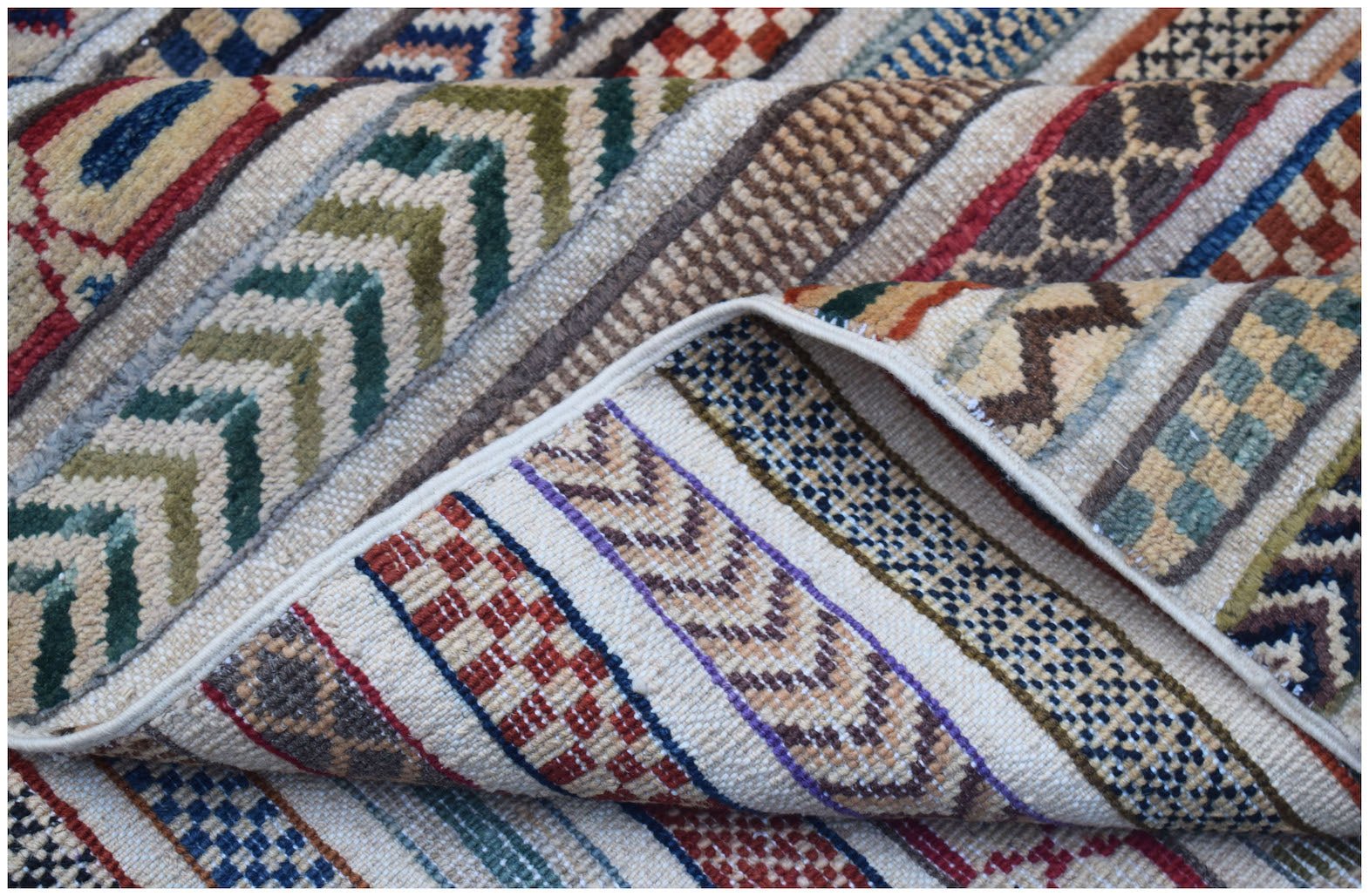 A handmade Afghan Yekta rug featuring a textured pattern of colorful geometric stripes.