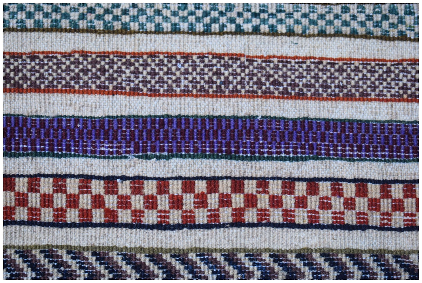 A handmade Afghan Yekta rug featuring horizontal bands of colorful geometric and checkered patterns.