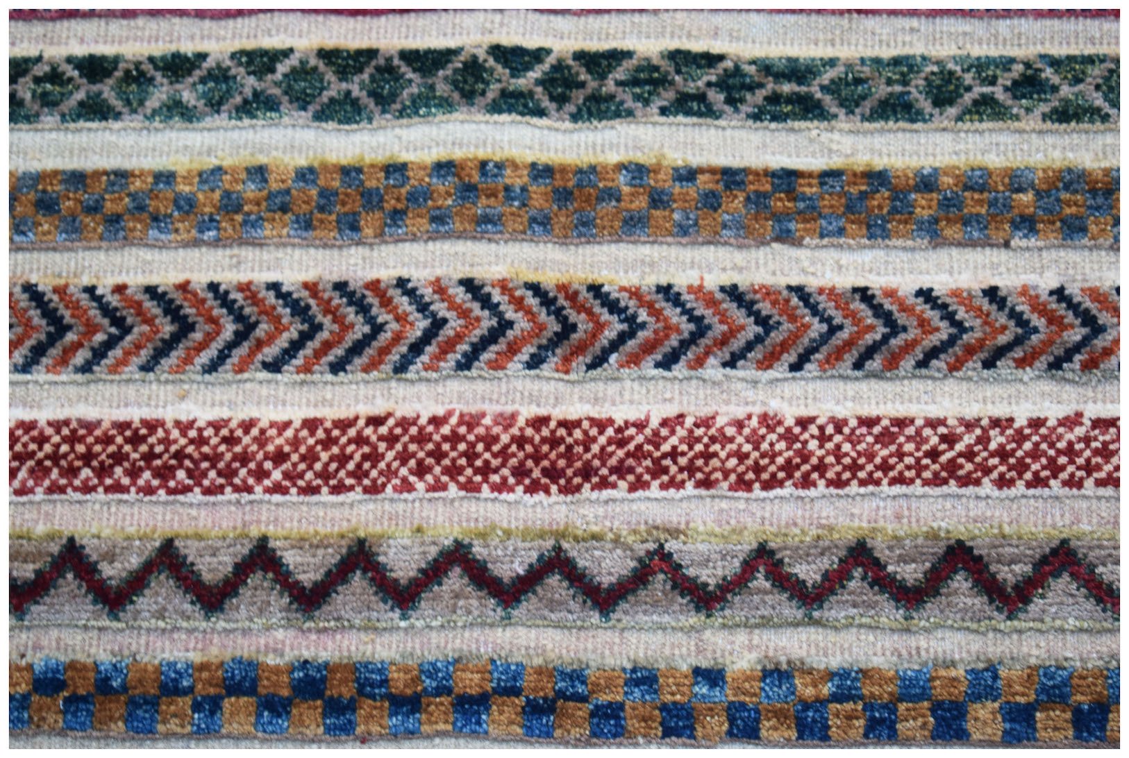 Handmade Afghan Yekta rug featuring horizontal bands of geometric patterns in wool.