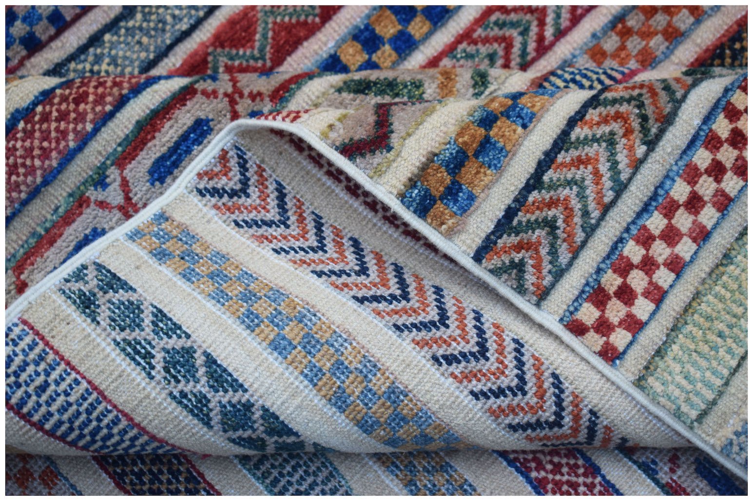 A handmade Afghan Yekta rug featuring a textured pattern of colorful geometric stripes.