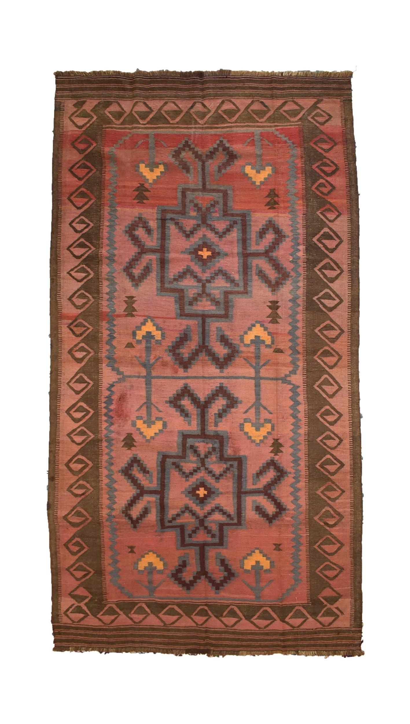 A vintage handmade Afghan kilim rug featuring geometric patterns in muted red and brown tones.