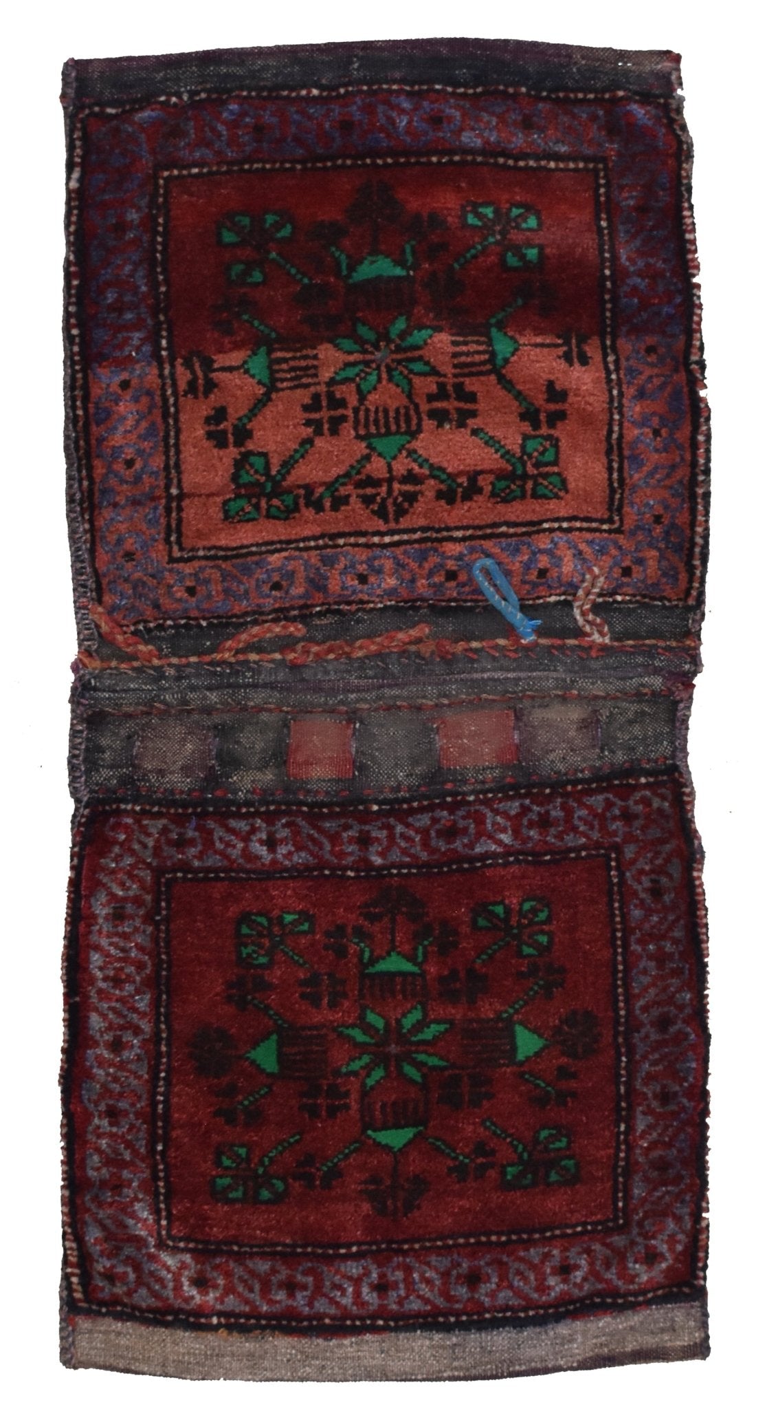 A handmade vintage Afghan wool saddle bag featuring two matching red panels with geometric motifs.
