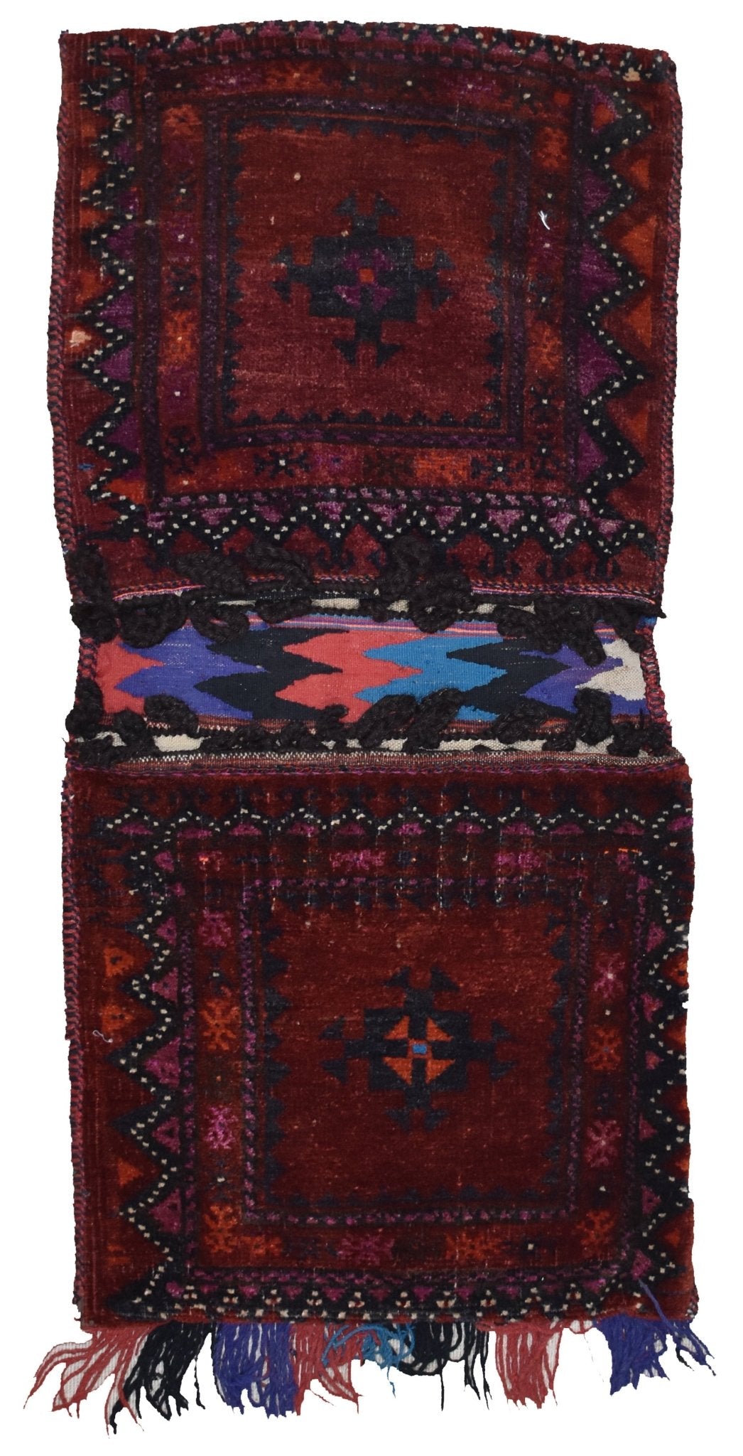 A handmade vintage Afghan wool saddle bag featuring two deep red panels with geometric motifs.
