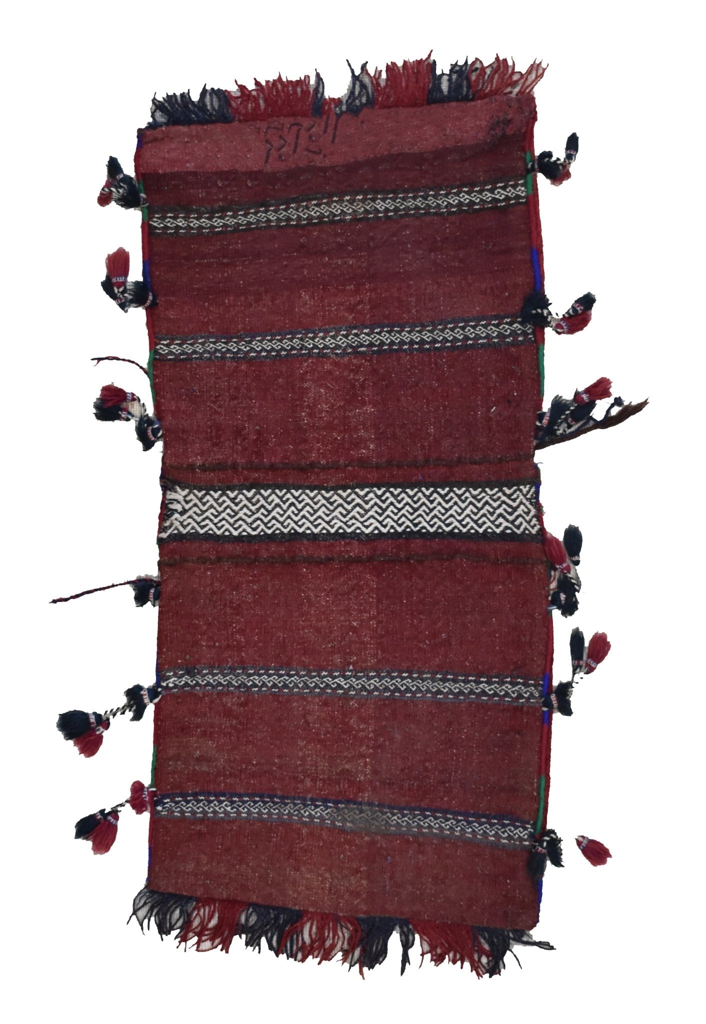A vintage handmade Afghan wool saddle bag featuring deep red tones and decorative tassels.