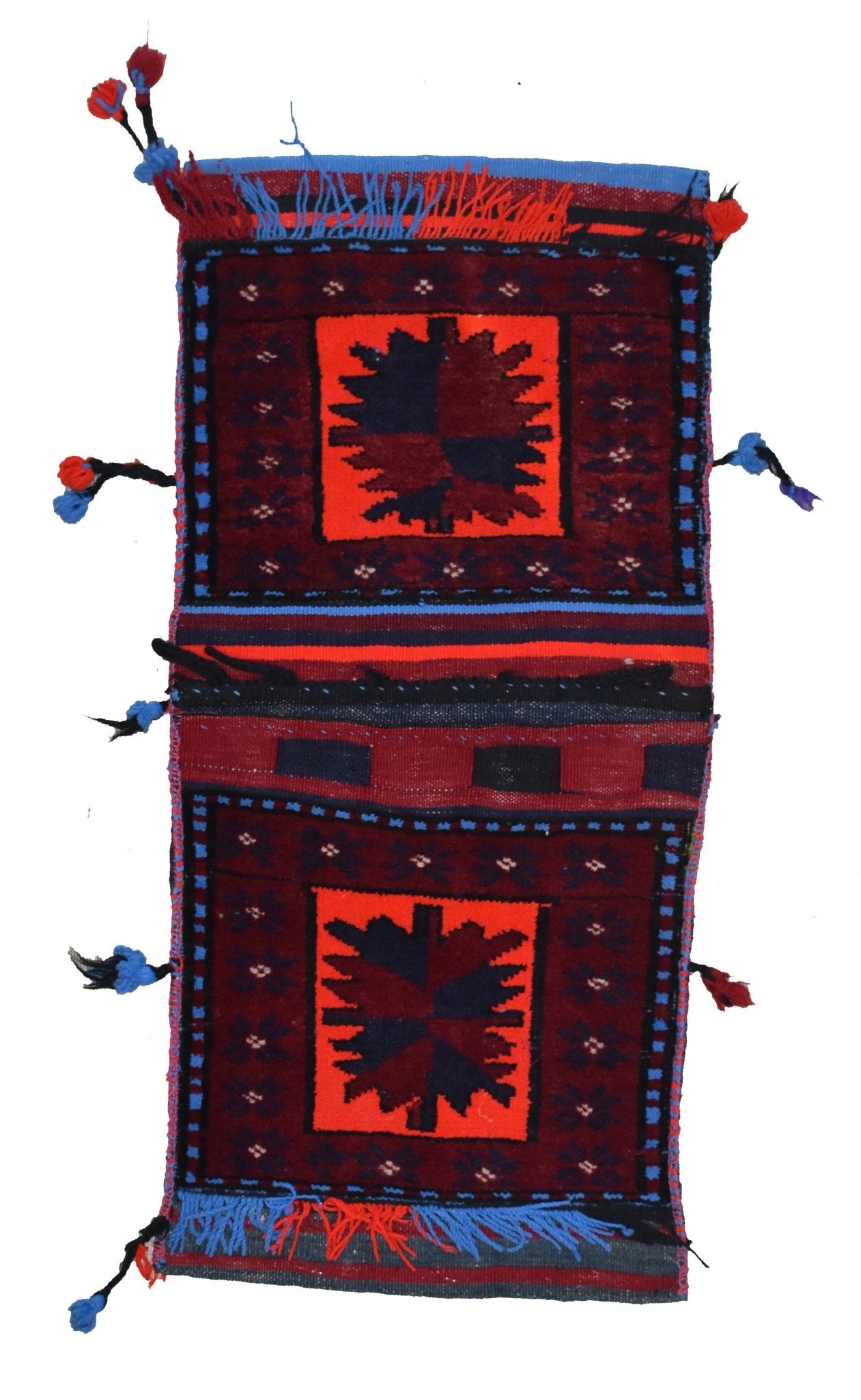 A handmade vintage Afghan wool saddle bag featuring two red panels with dark geometric motifs.