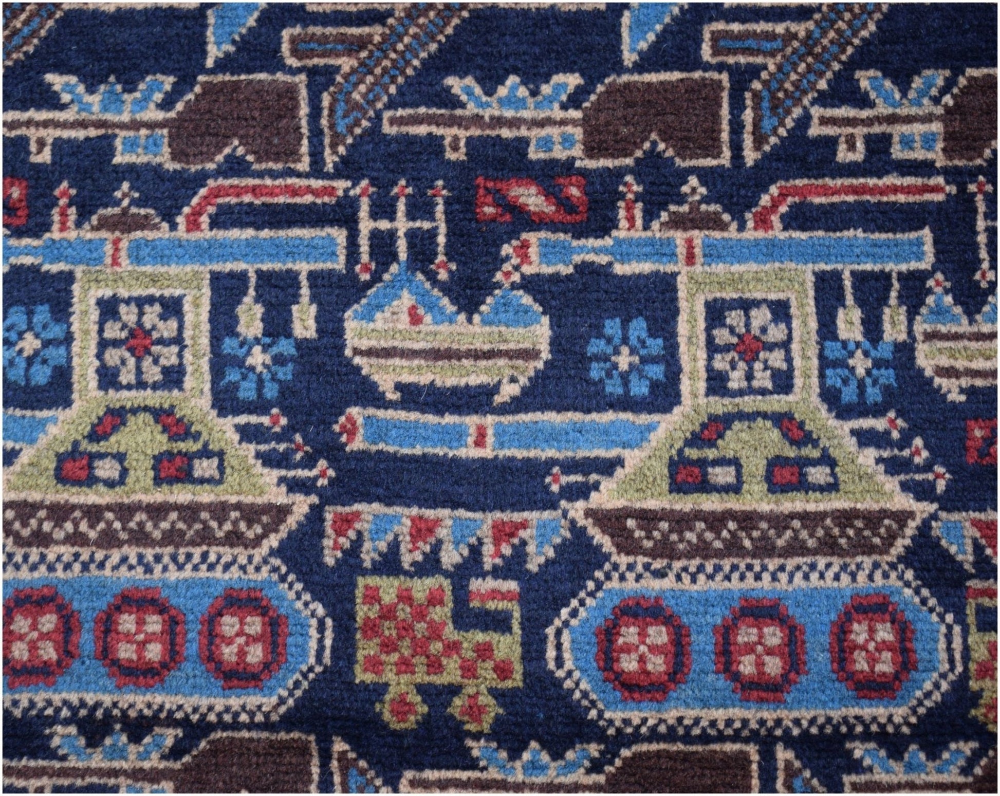 Handmade Afghan wool rug featuring a dark blue field with repeating tank and military motifs.