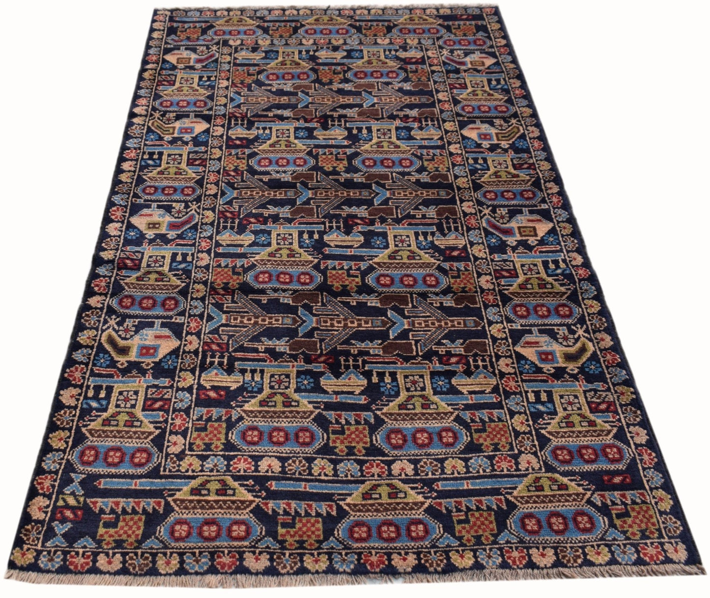 A handmade Afghan wool rug featuring a dark blue field with repeating patterns of tanks and planes.