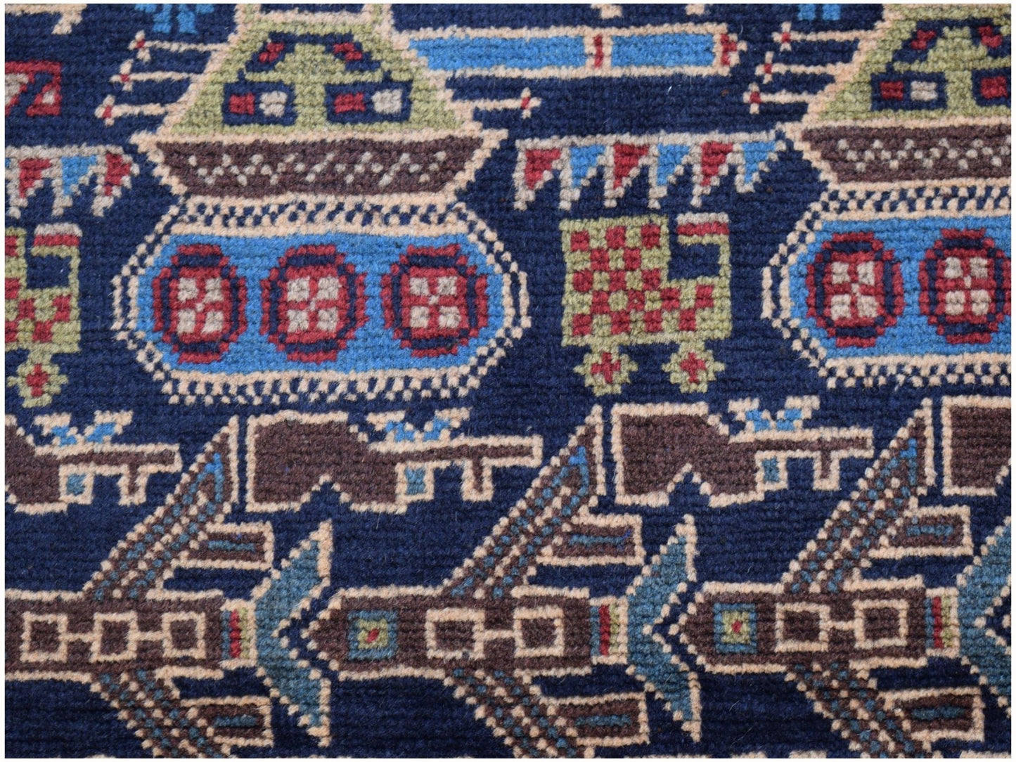 A handmade Afghan wool rug featuring a dark blue background with woven military tank motifs.