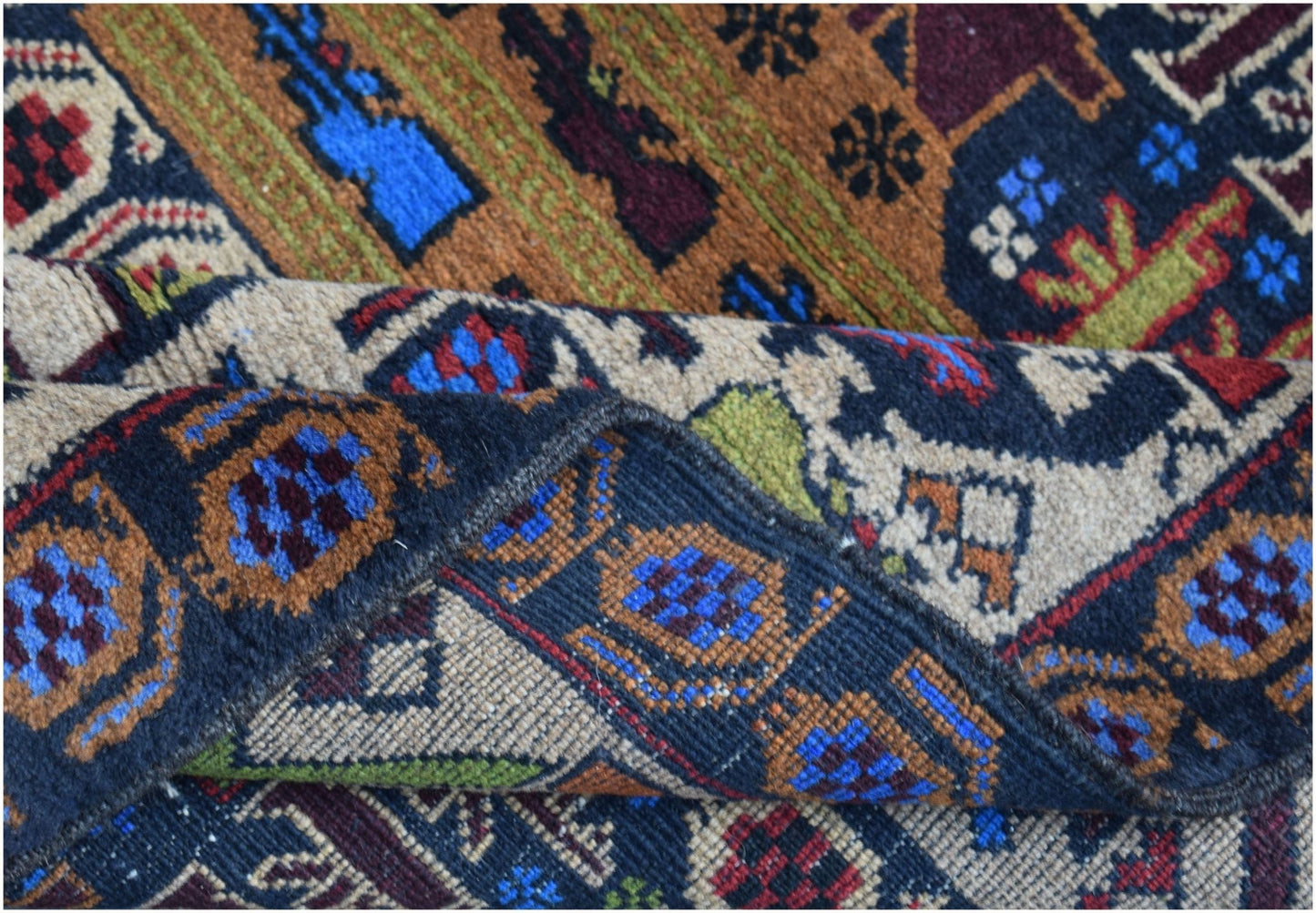 A handmade Afghan wool rug featuring intricate geometric patterns in blue, red, and brown tones.