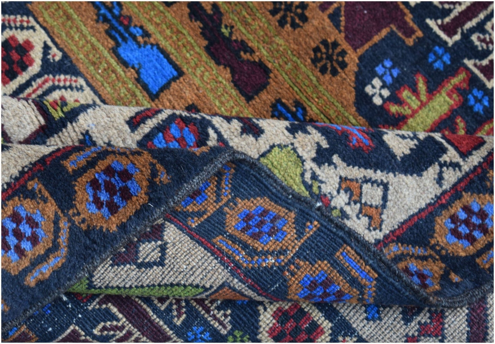 A handmade Afghan wool rug featuring intricate geometric patterns in blue, red, and brown tones.
