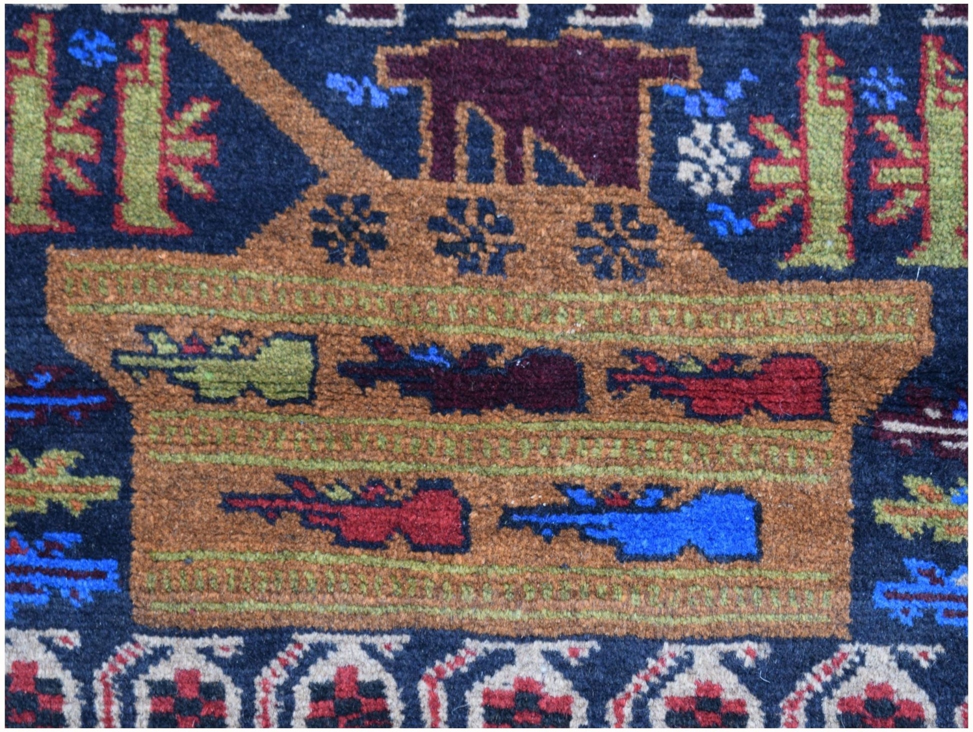 A handmade Afghan wool rug featuring a woven depiction of a tank against a dark blue background.