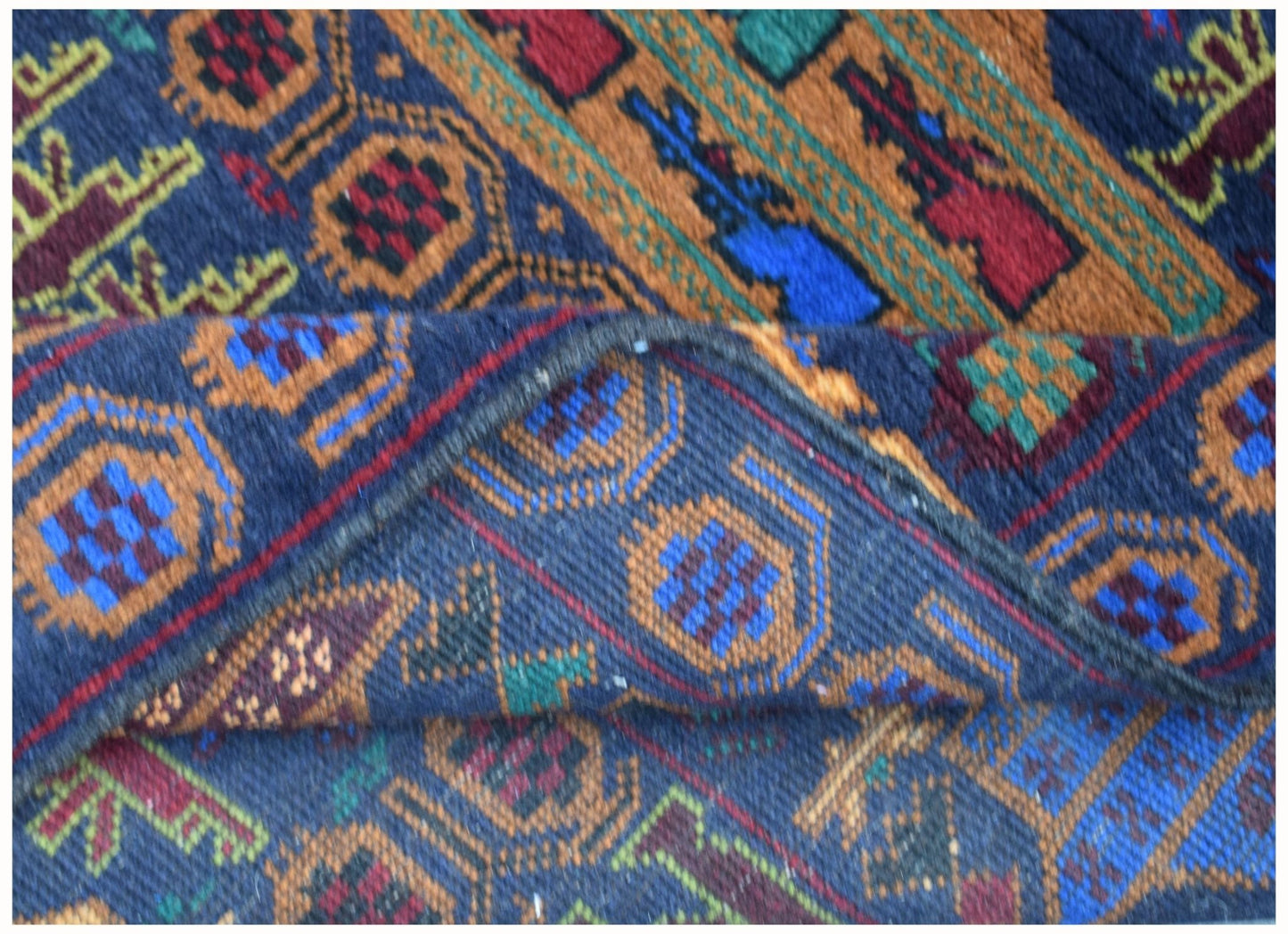 A handmade Afghan wool rug featuring geometric patterns in blue, orange, red, and green.