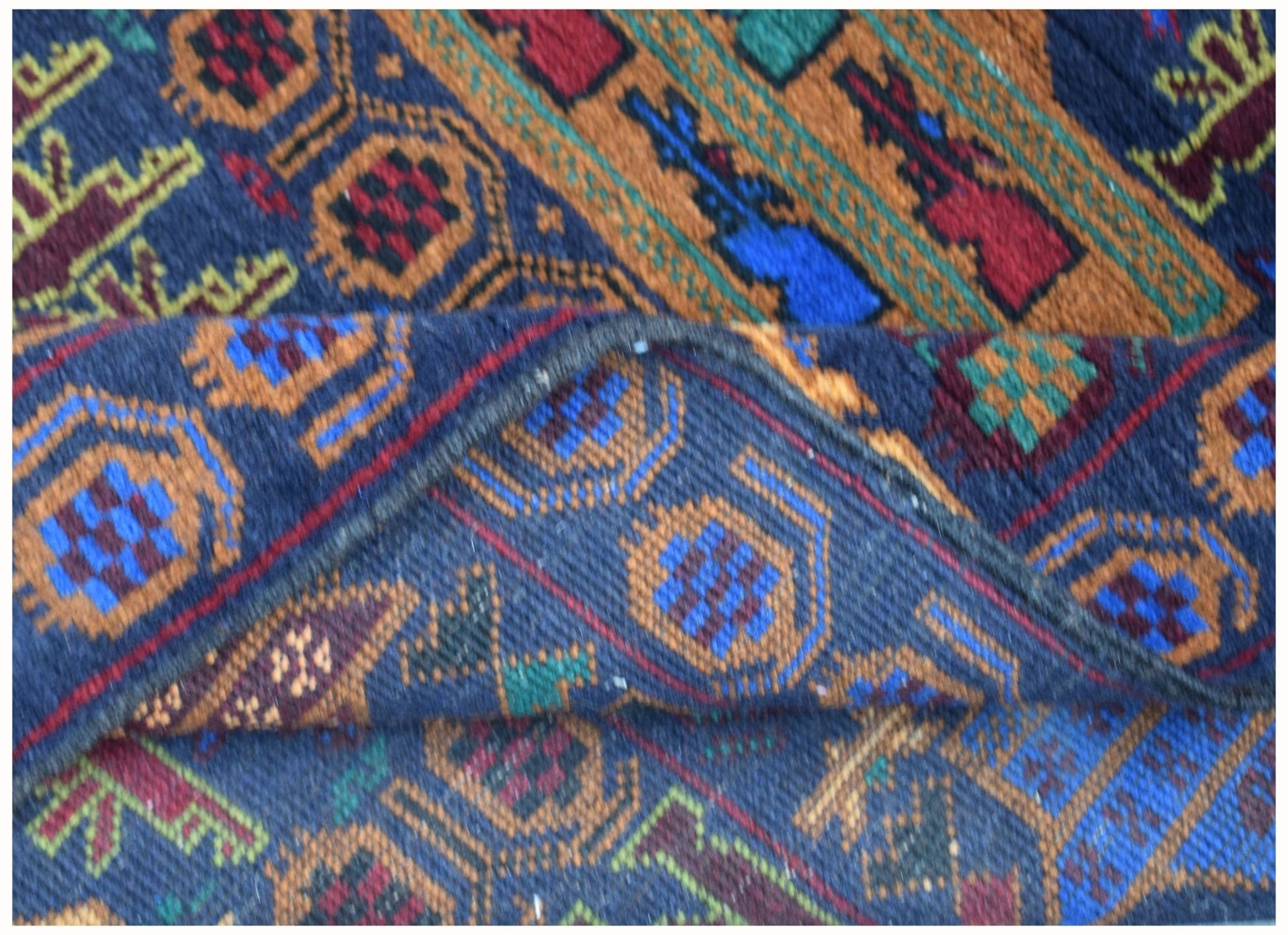A handmade Afghan wool rug featuring geometric patterns in blue, orange, red, and green.
