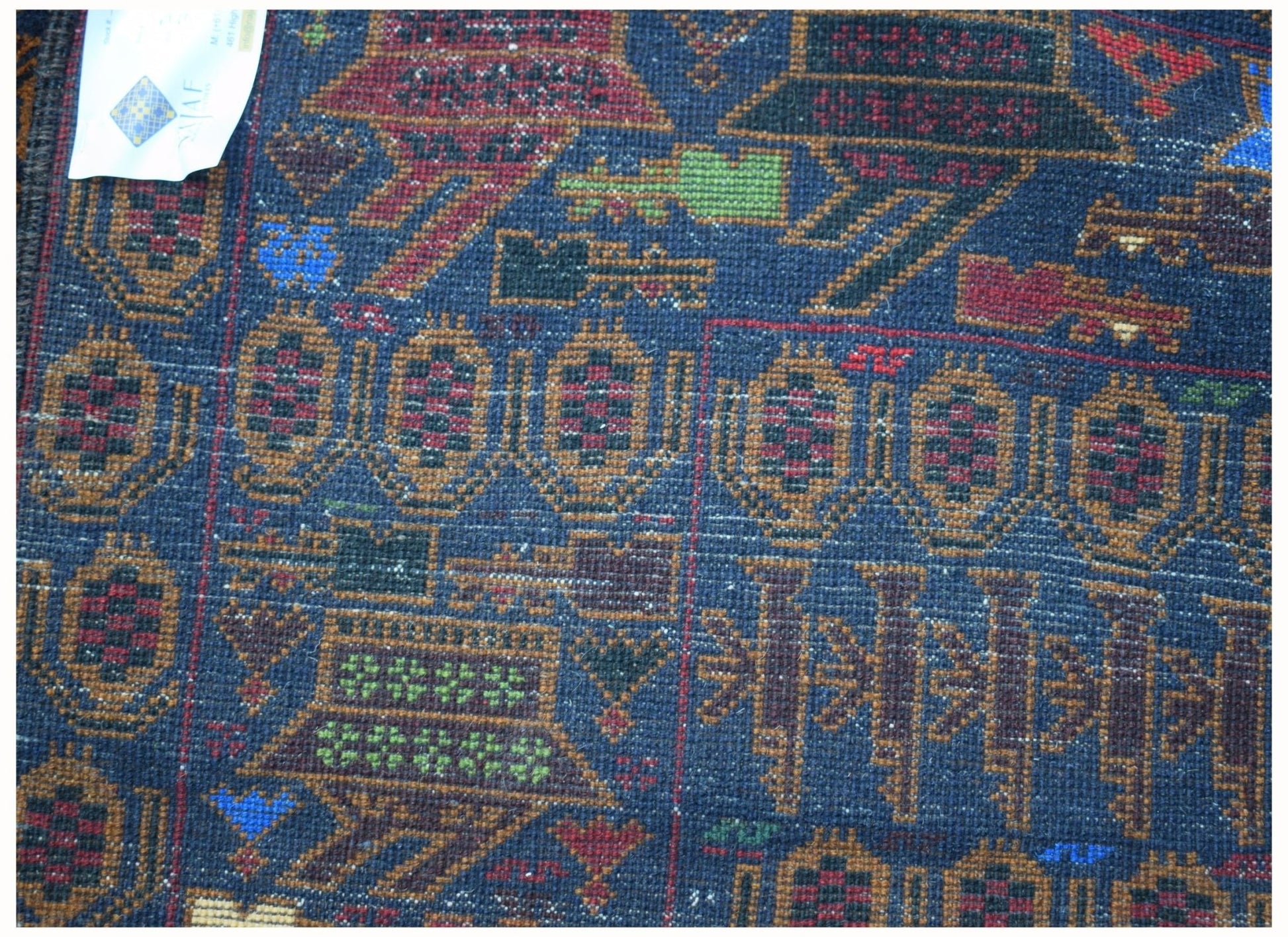 Handmade Afghan wool rug featuring intricate geometric patterns and traditional war motifs.