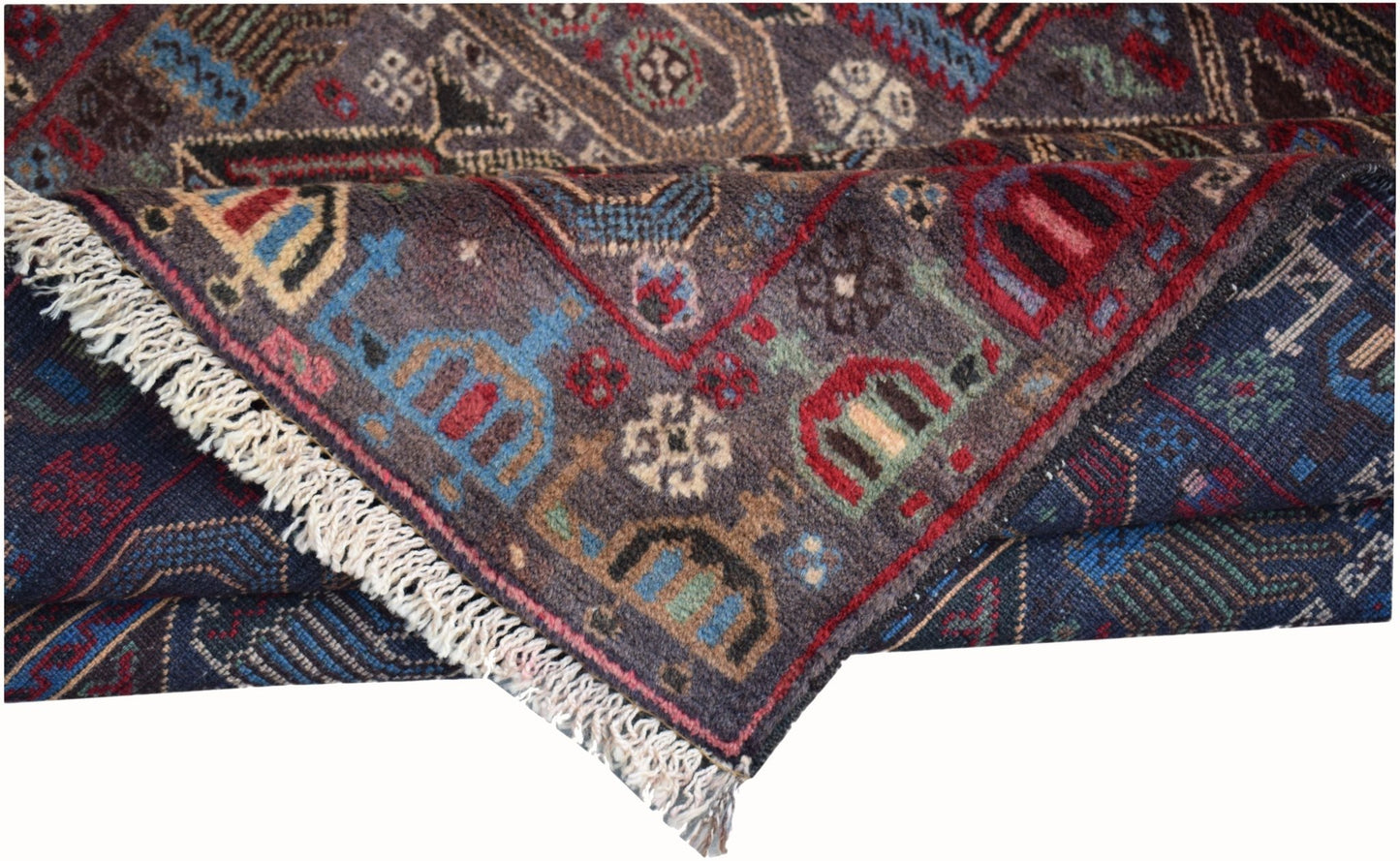 A handmade Afghan wool rug featuring intricate geometric patterns and a fringed edge.