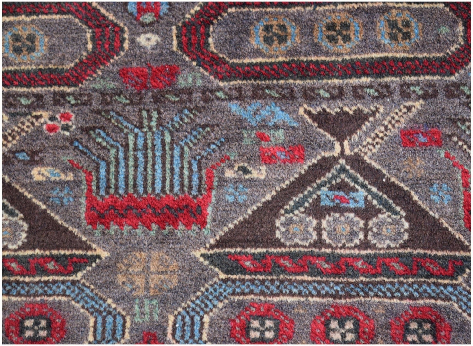 Handmade Afghan wool rug featuring geometric patterns and traditional war-themed motifs.