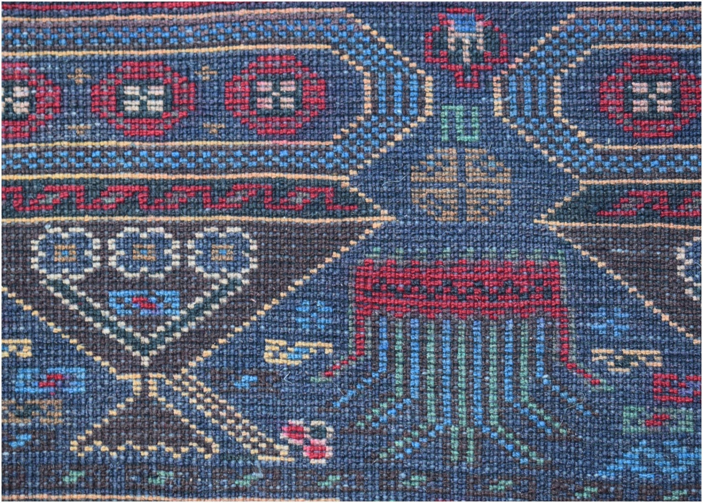 Handmade Afghan wool rug featuring intricate geometric patterns and traditional motifs in blue.