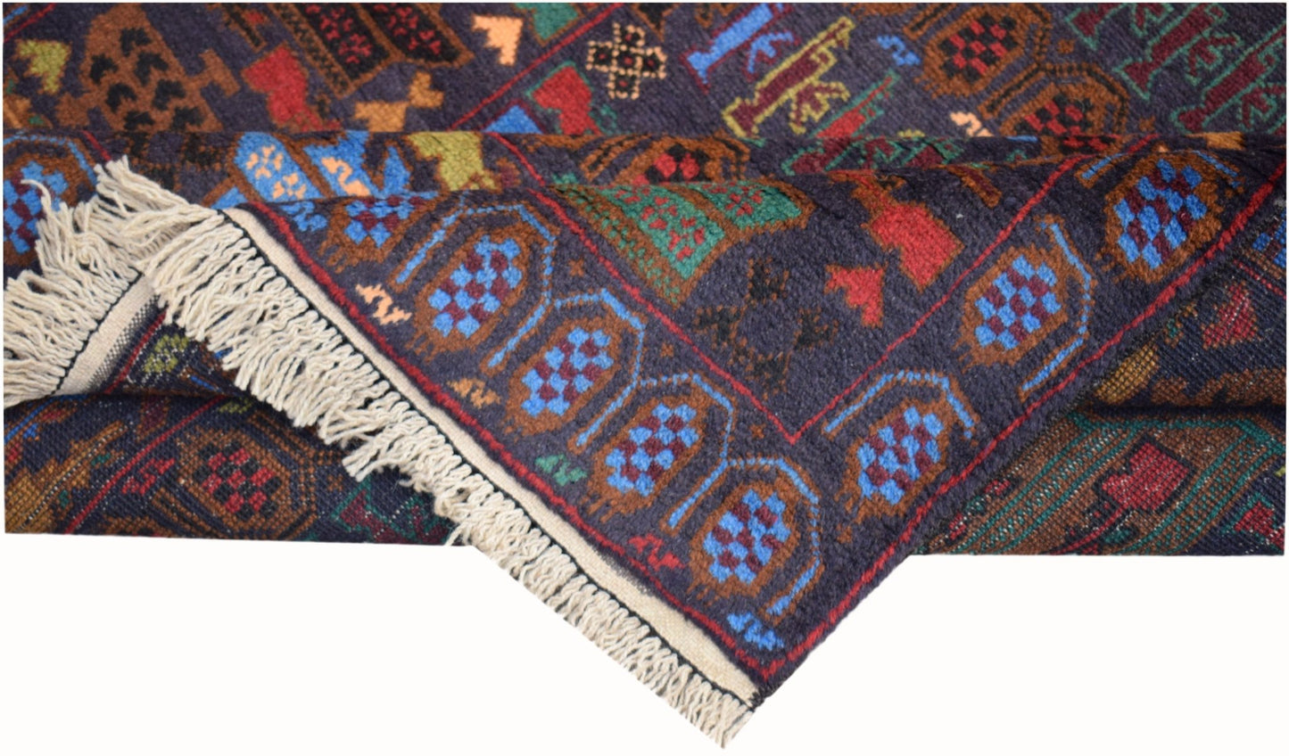 A handmade Afghan wool rug featuring a dark blue field with geometric patterns and fringe ends.