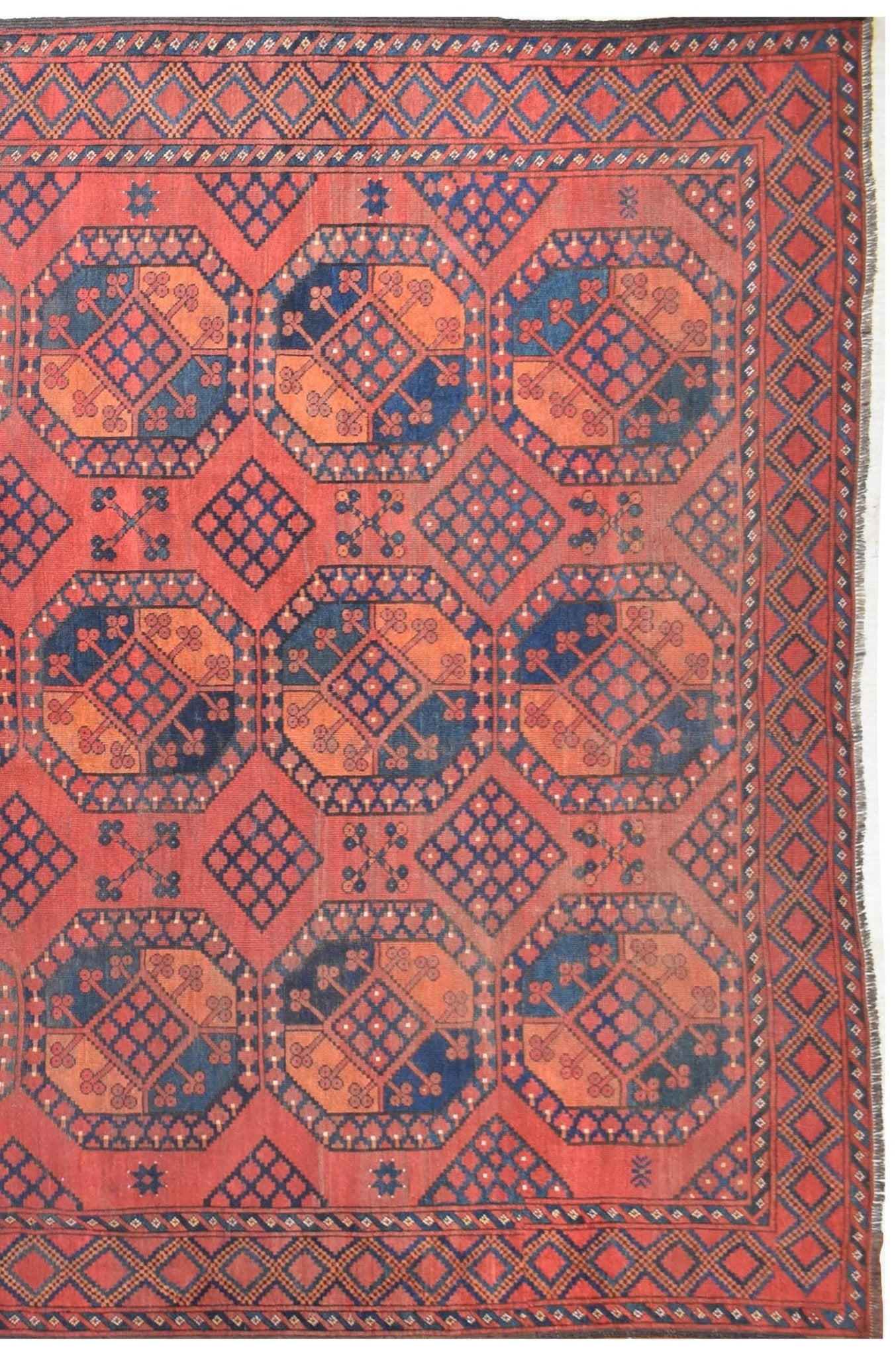 An antique Afghan Turkmen rug featuring a repeating geometric elephant foot motif in red and blue.