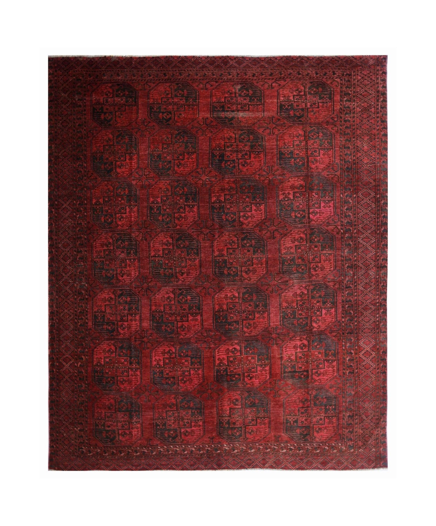 An antique Afghan Turkmen rug featuring repeating dark elephant foot motifs on a vibrant red field.
