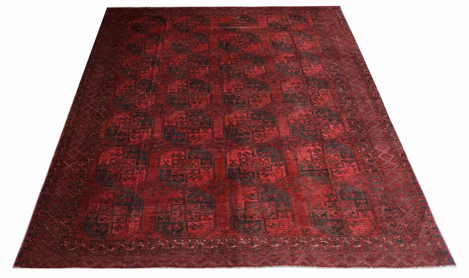 Handmade antique Afghan Turkmen rug featuring a repeating red and black elephant foot pattern.